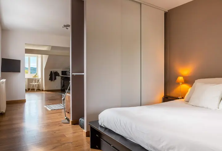 Chambre avec lit double et lampe de chevet allumée