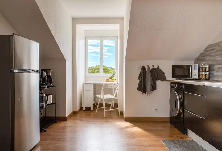 Coin cuisine sous les combles avec réfrigérateur et petit bureau