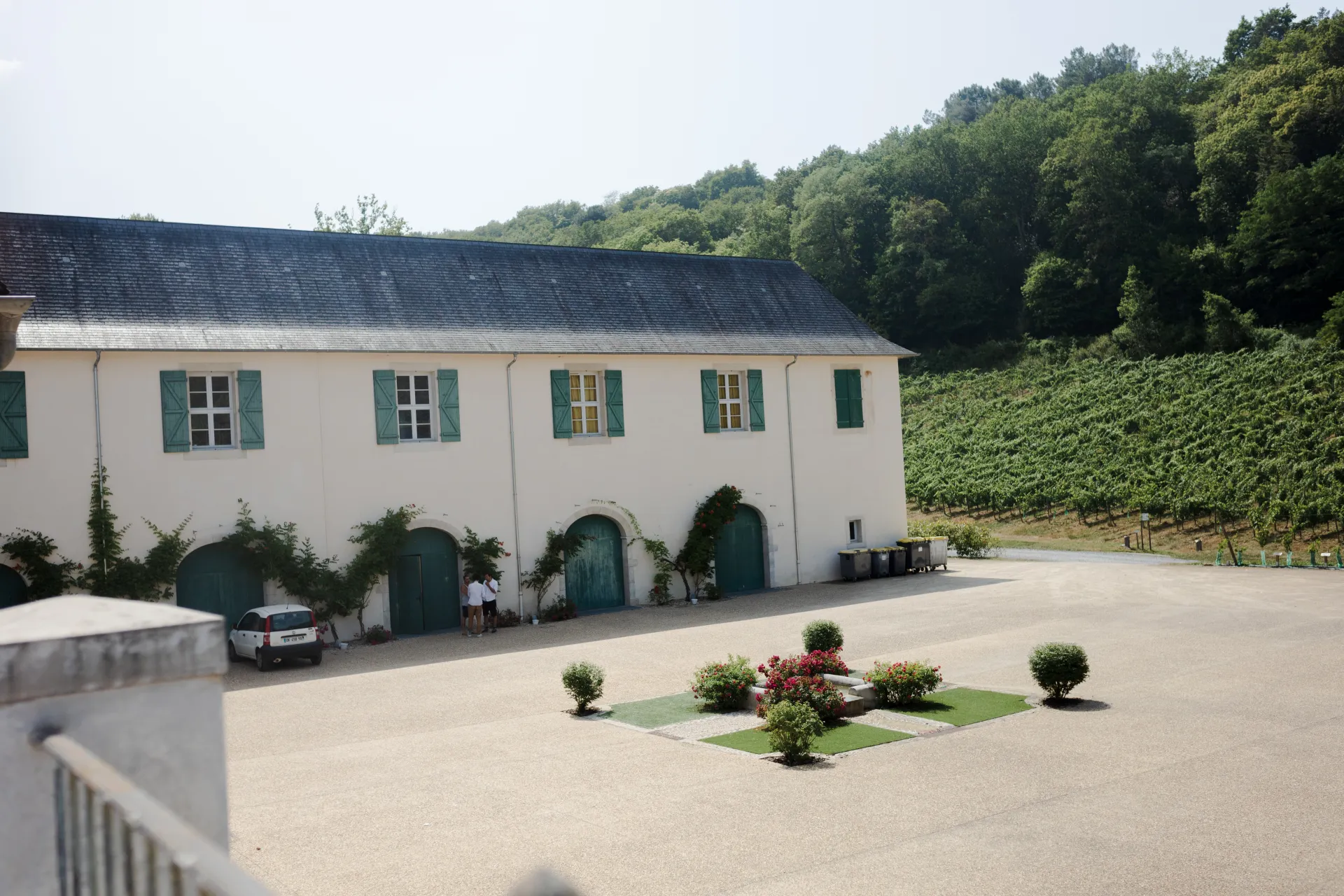 Domaine de mariage près de Pau dans les Pyrénées-Atlantiques, avec cour lumineuse, bâtisse blanche et vignoble en arrière-plan