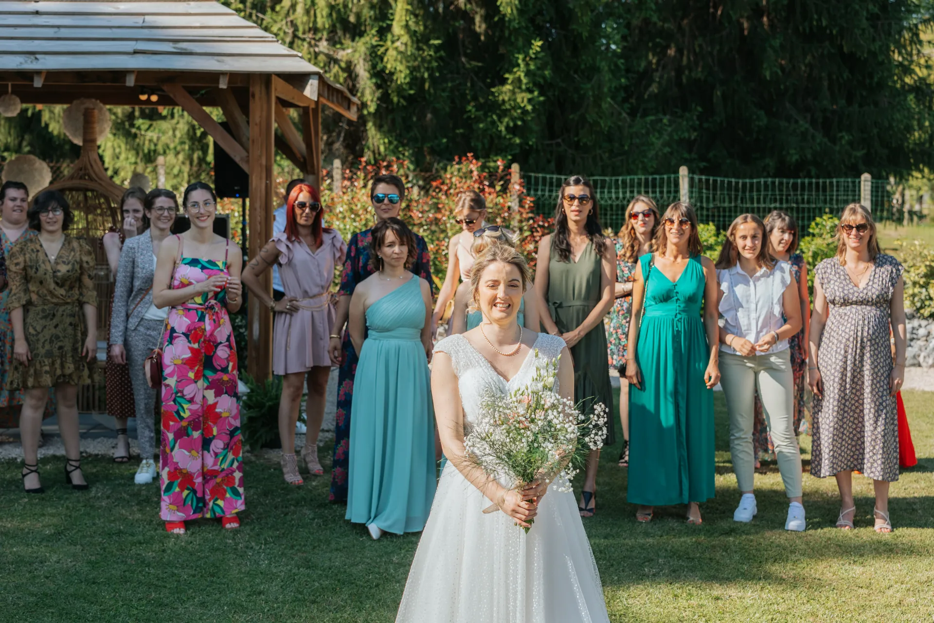 Mariée lançant son bouquet devant ses invitées dans un jardin de domaine de mariage à Pau, dans les Pyrénées-Atlantiques
