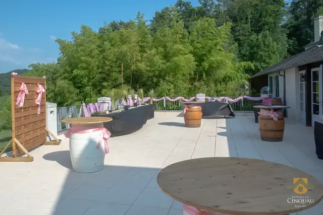 Terrasse de réception décorée pour un mariage à Pau dans les Pyrénées-Atlantiques, avec tables et rubans roses