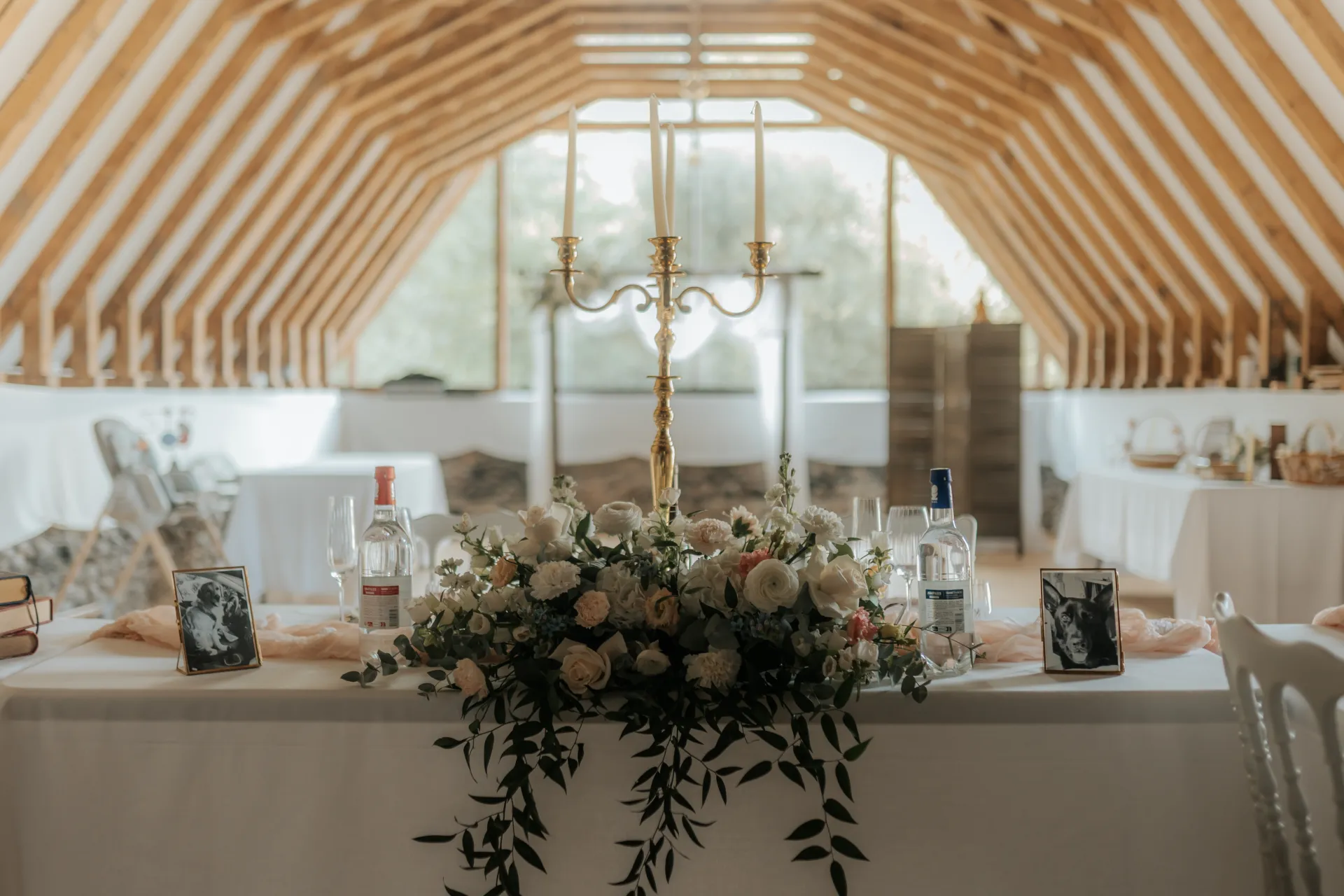 Table des mariés décorée de fleurs dans une salle de réception en bois, lieu de mariage élégant à Pau
