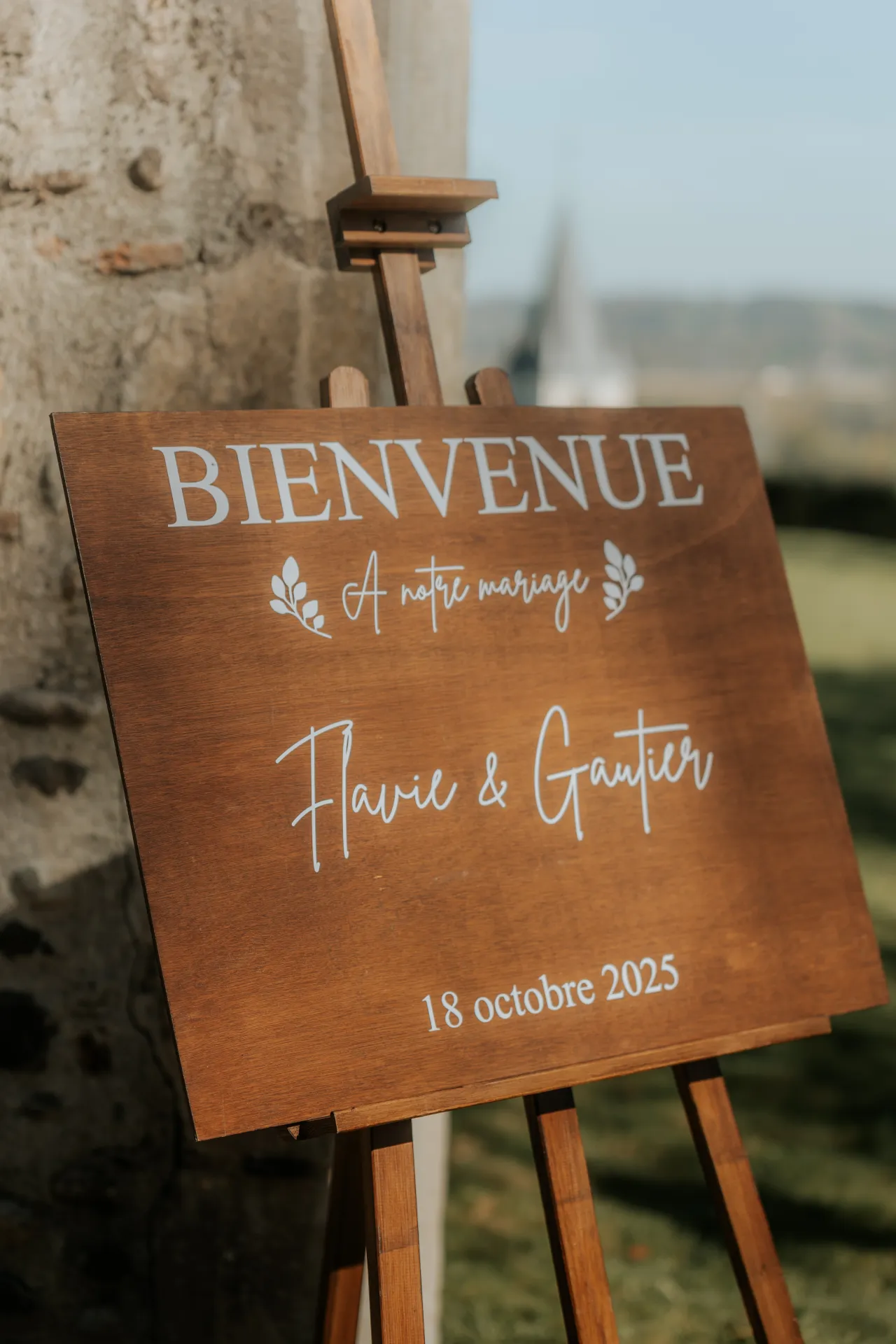 Panneau de bienvenue en bois pour mariage à Pau, présenté sur chevalet dans un lieu de réception des Pyrénées-Atlantiques