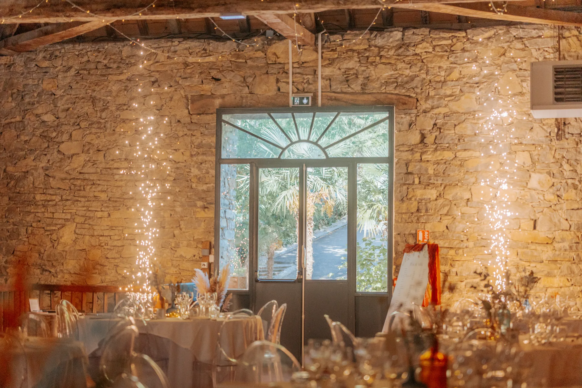 Salle de réception de mariage en pierre décorée de guirlandes lumineuses près de Pau, dans les Pyrénées-Atlantiques