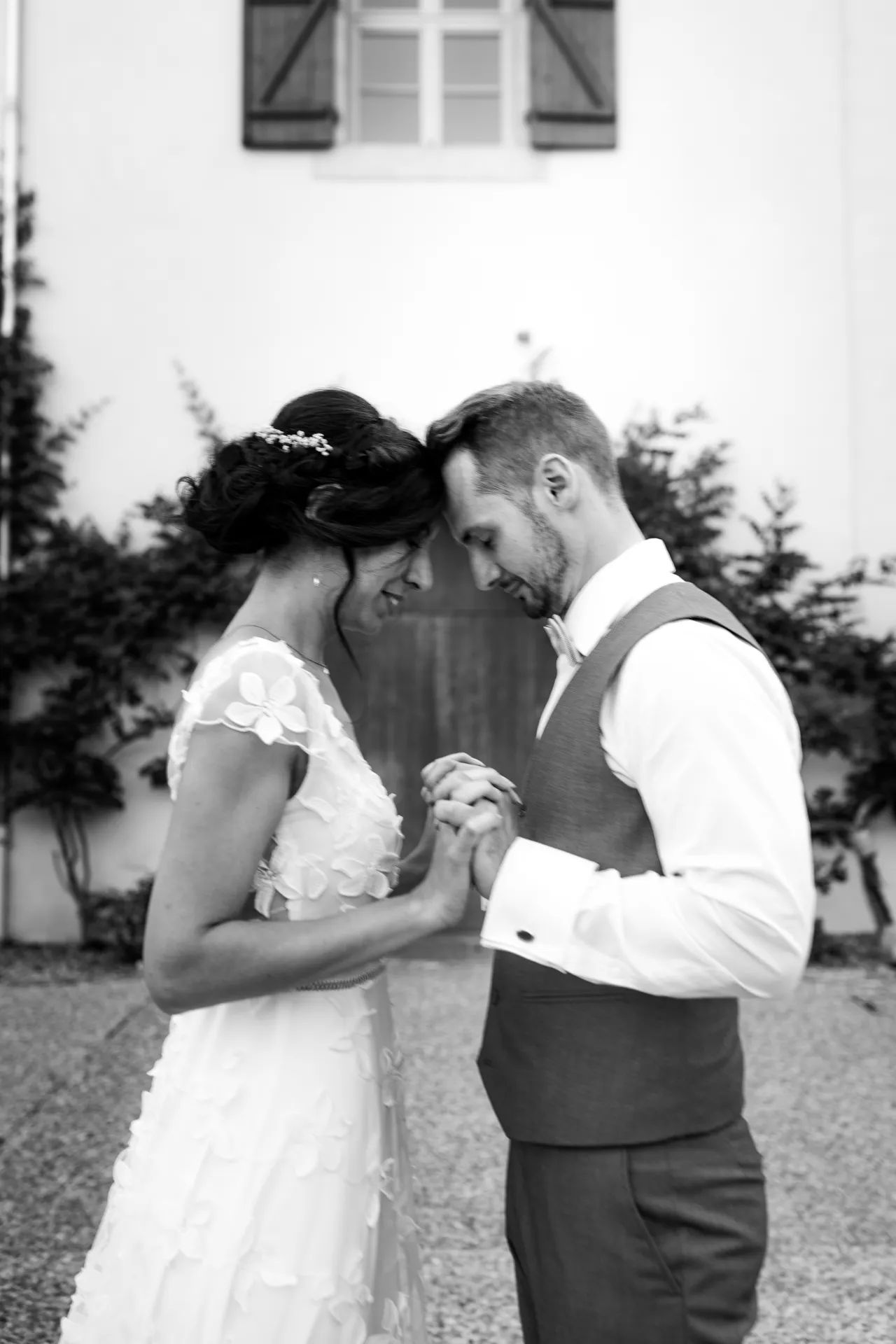 Couple de mariés main dans la main devant un domaine de mariage à Pau, dans les Pyrénées-Atlantiques