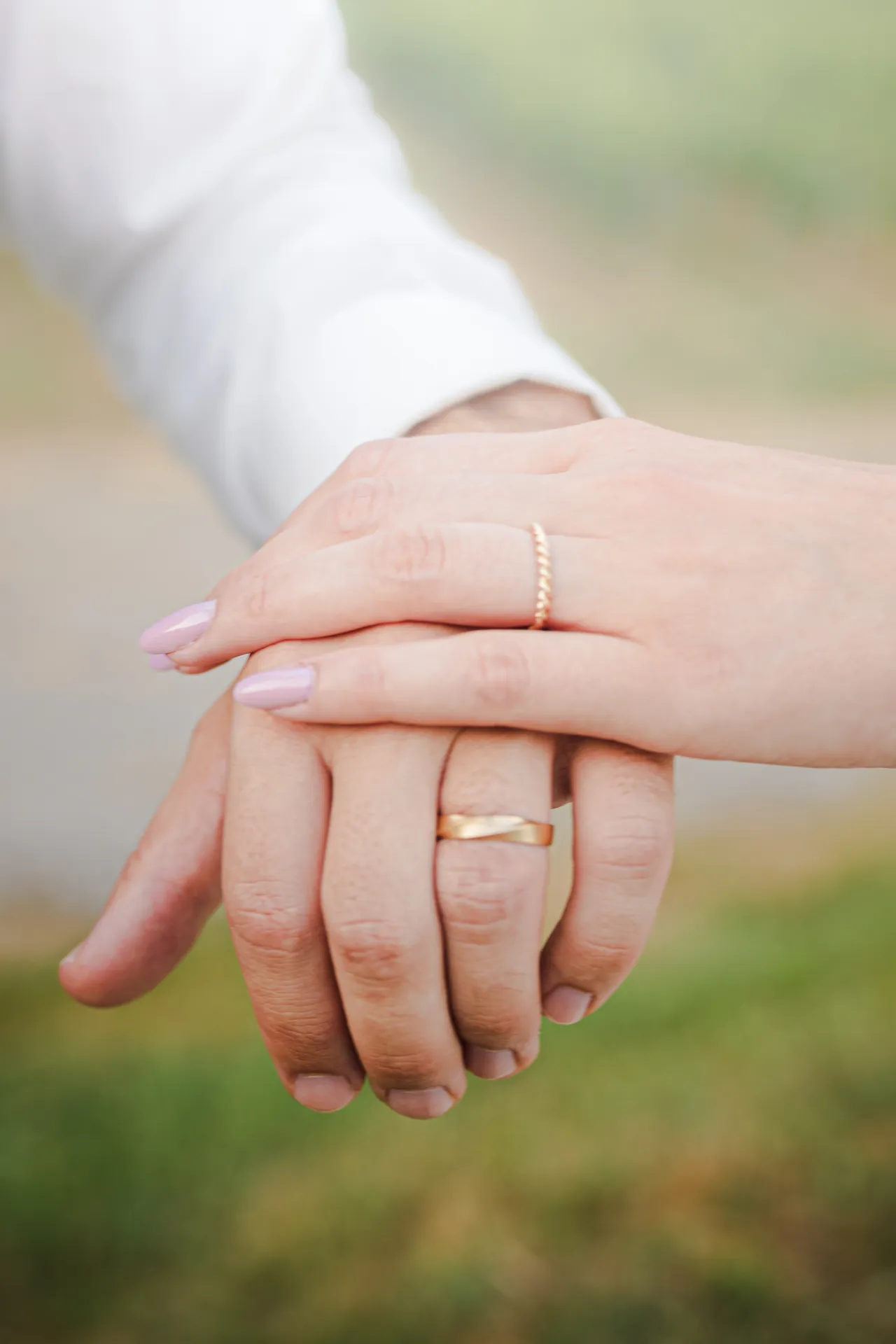 Mains enlacées de mariés avec alliances, photo de mariage romantique à Pau dans les Pyrénées-Atlantiques