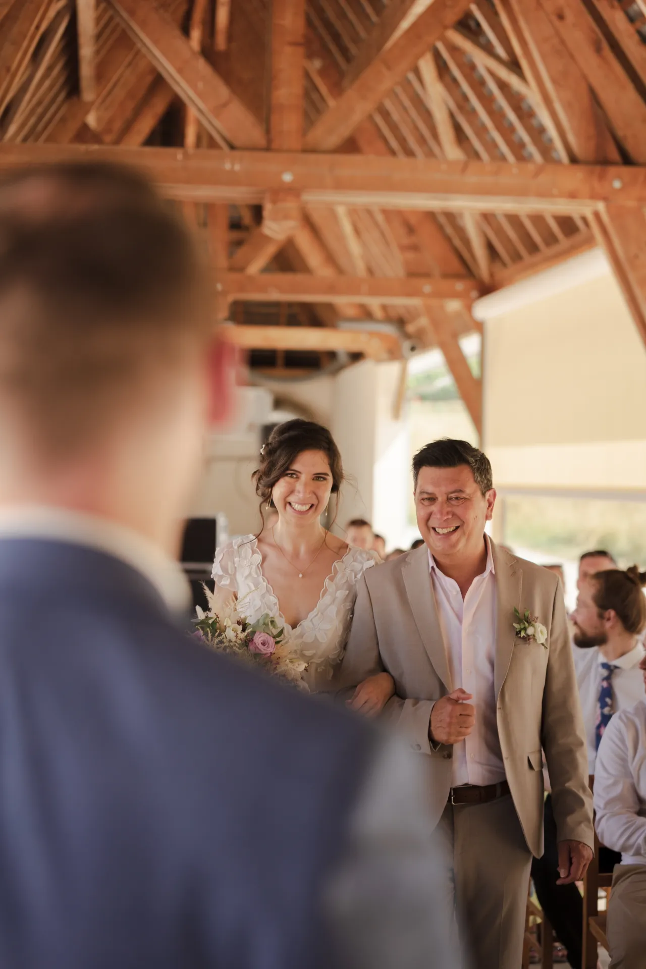 Mariée entrant à la cérémonie au bras de son père dans un lieu de mariage chaleureux à Pau, Pyrénées-Atlantiques