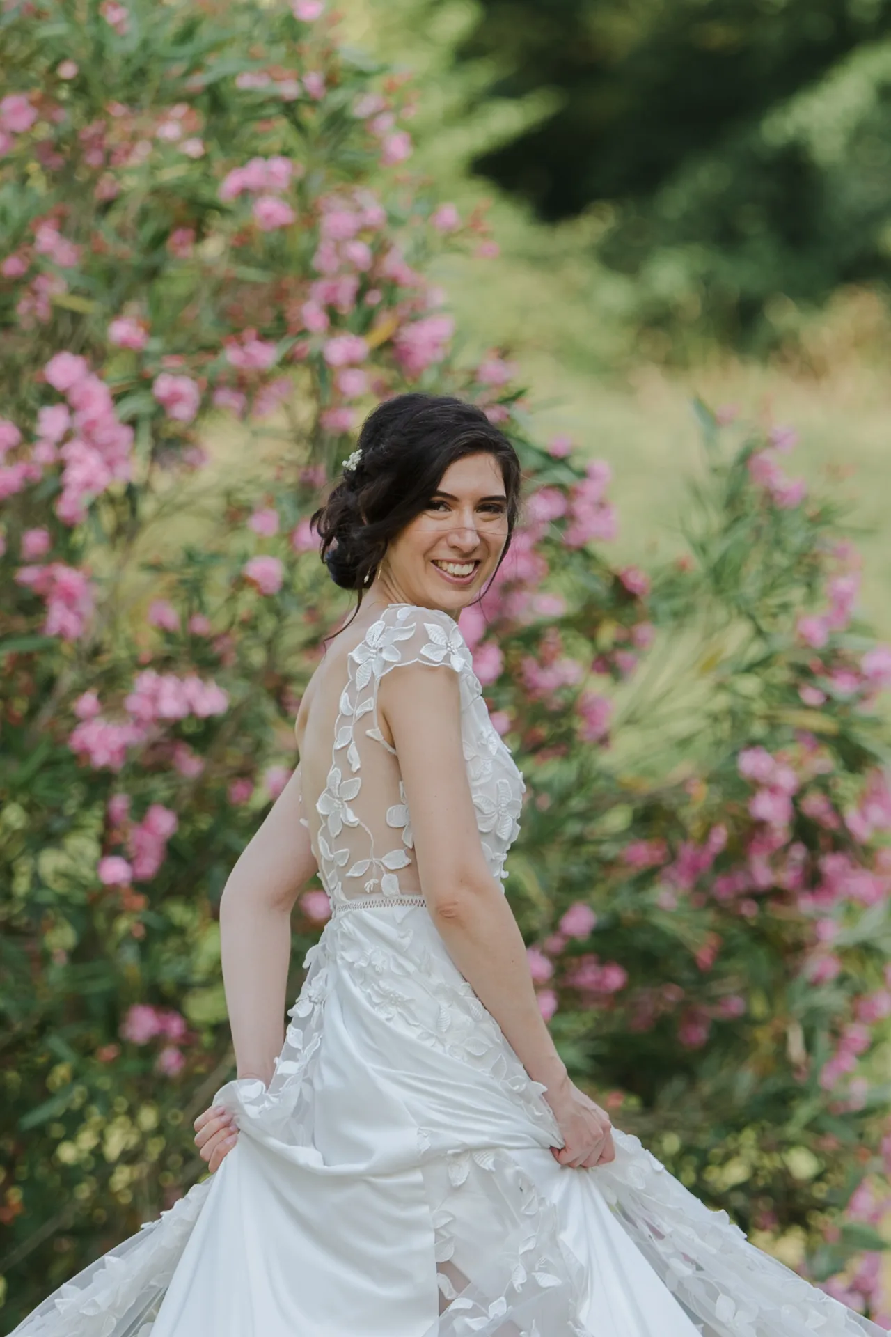 Mariée souriante en robe blanche dans un jardin fleuri, inspiration mariage à Pau dans les Pyrénées-Atlantiques