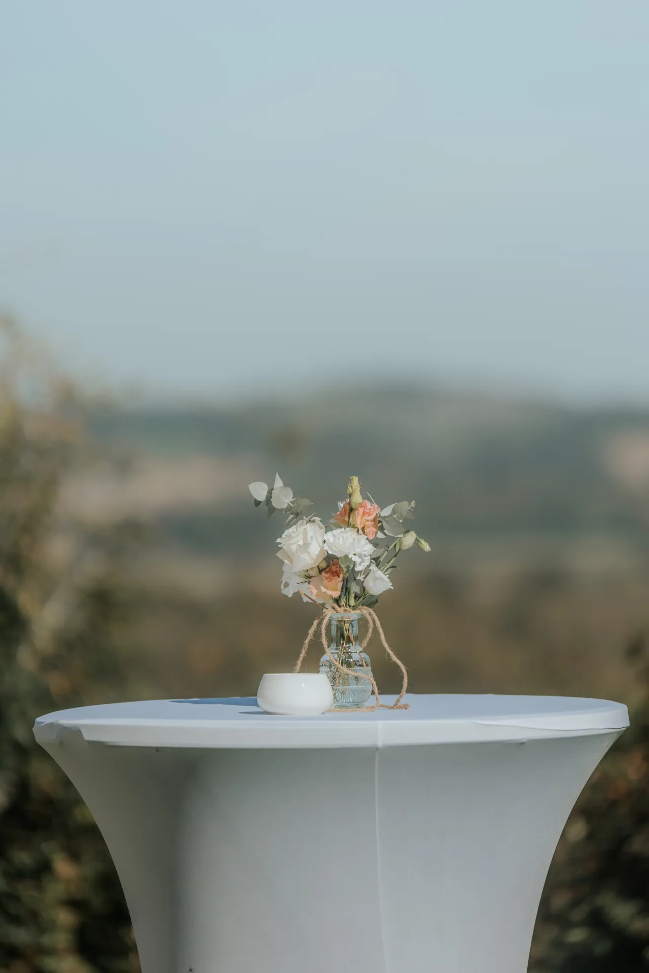 Table de cocktail décorée de fleurs pour un mariage à Pau, avec vue sur les Pyrénées-Atlantiques