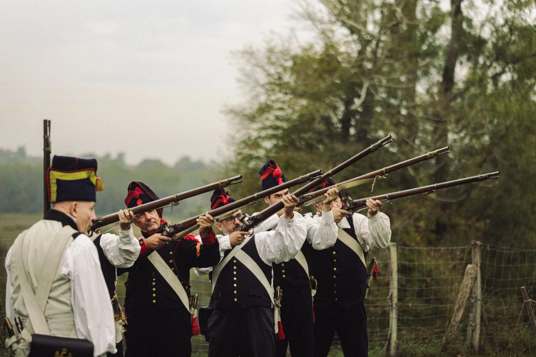 Reconstituteurs en costumes d’époque tirant au fusil au Château de Bidache lors d’un événement patrimonial immersif