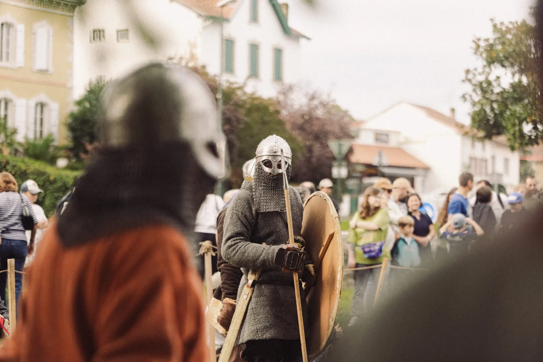 Combattants en costumes médiévaux devant le public au Château de Bidache lors d’un événement patrimonial immersif