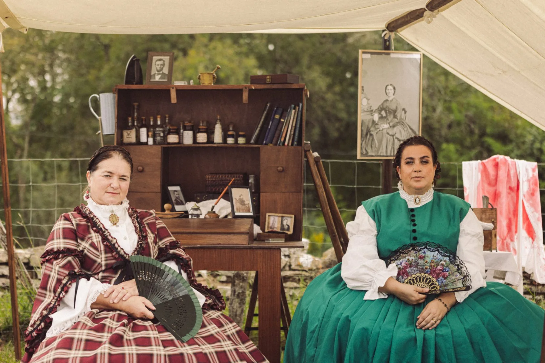 Deux femmes en costumes d’époque sous une tente au Château de Bidache, entre artisanat, portraits anciens et ambiance patrimoniale