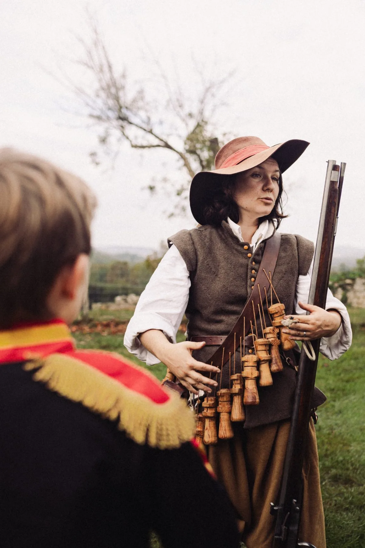 Femme en costume d’époque avec accessoires artisanaux au Château de Bidache lors d’un événement patrimonial immersif