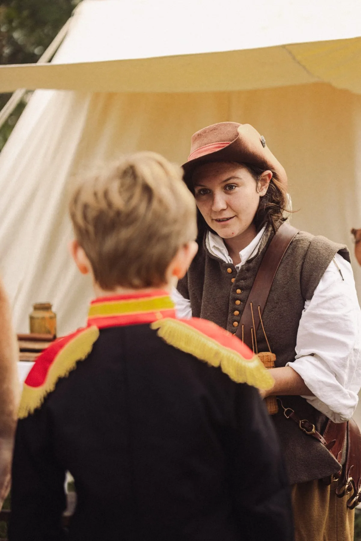 Artisane en costume d’époque échangeant avec des visiteurs au Château de Bidache lors d’un événement patrimonial immersif