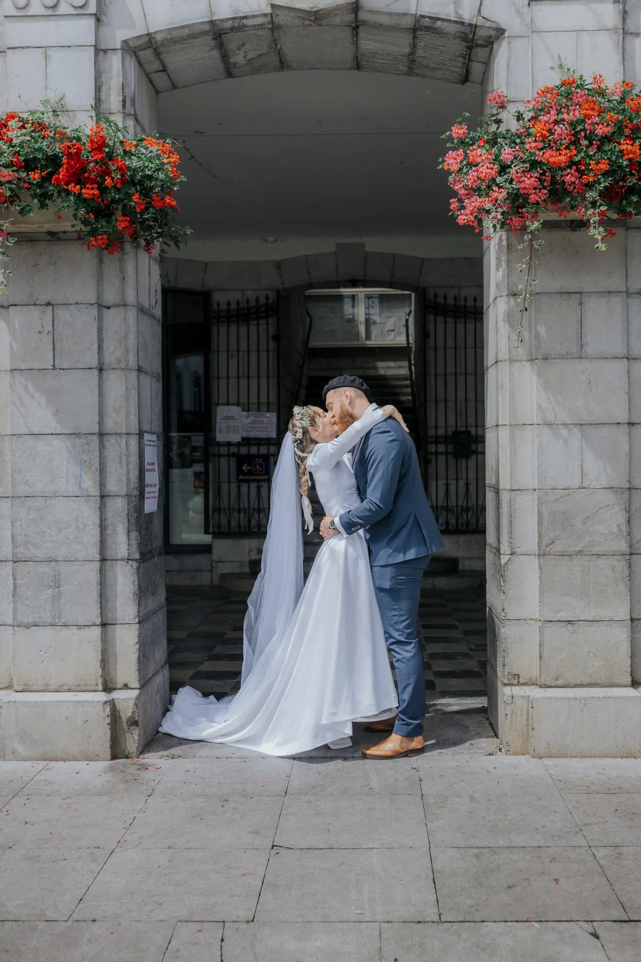 Mariés s’embrassant sous le porche de la mairie d’Arudy lors d’un mariage intimiste dans les Pyrénées-Atlantiques