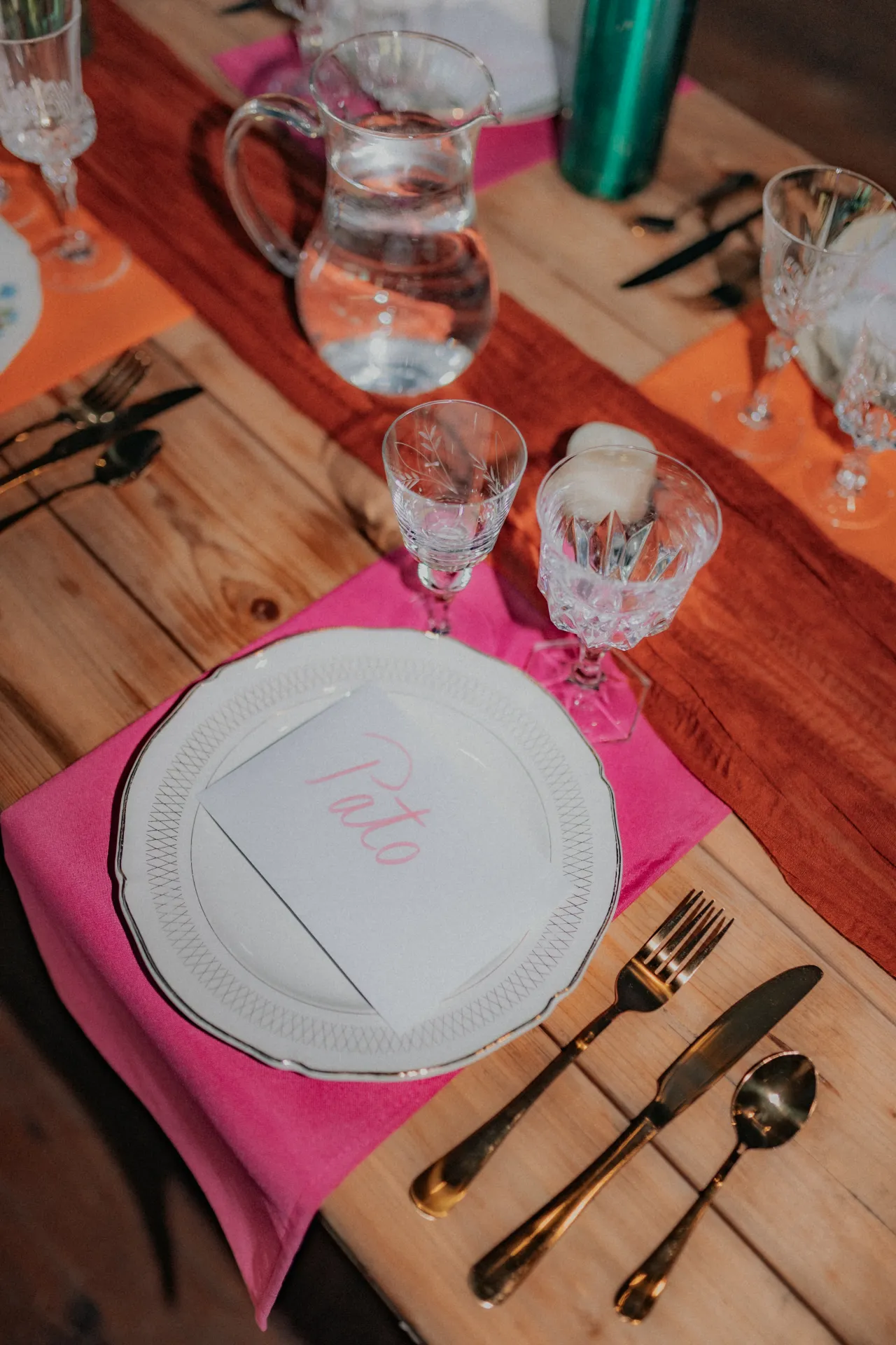 Table de mariage vintage à Pau avec assiette élégante, serviette rose, verres ciselés et déco naturelle en bois