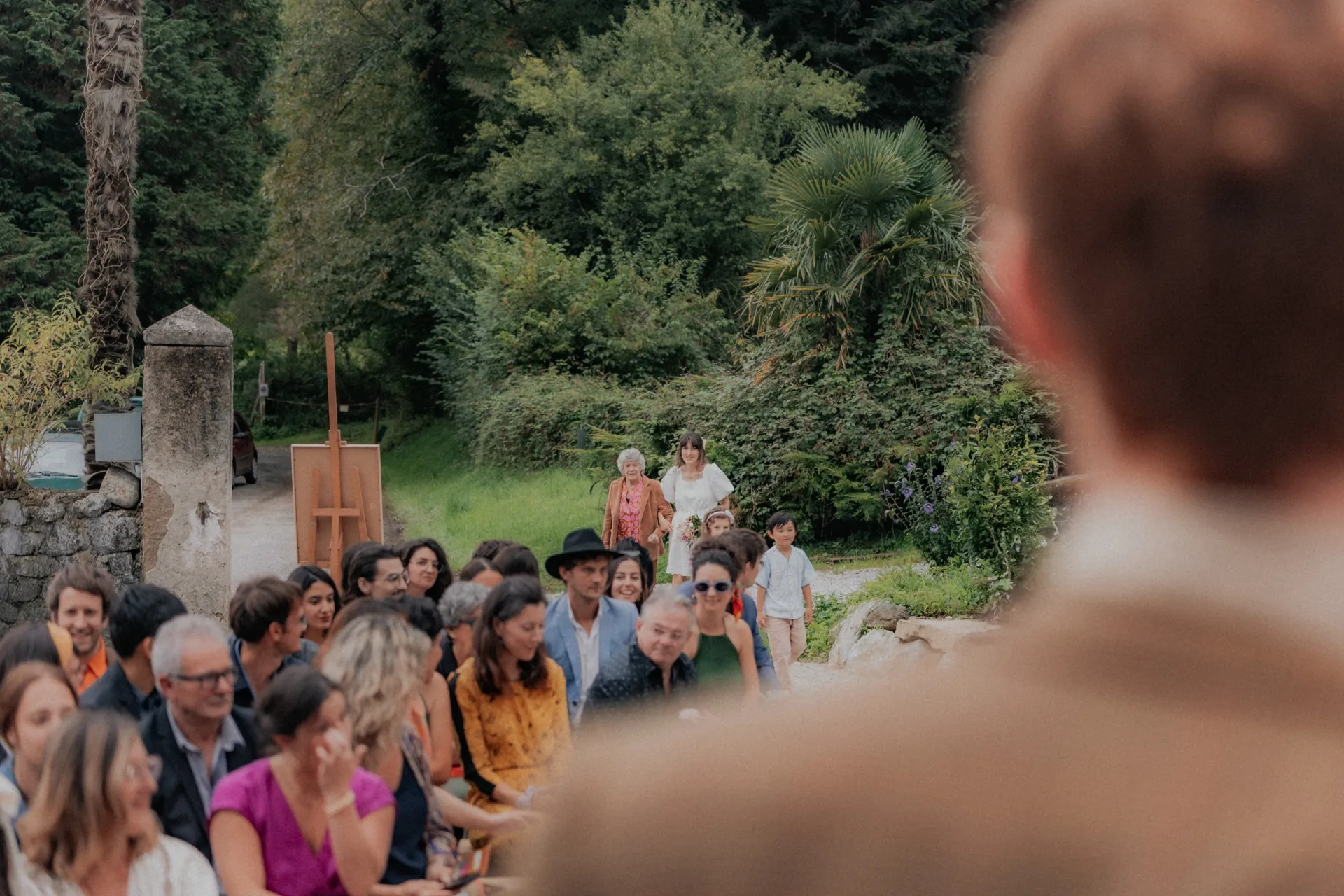 Cérémonie de mariage vintage en pleine nature à Pau, invités assis dans un jardin arboré