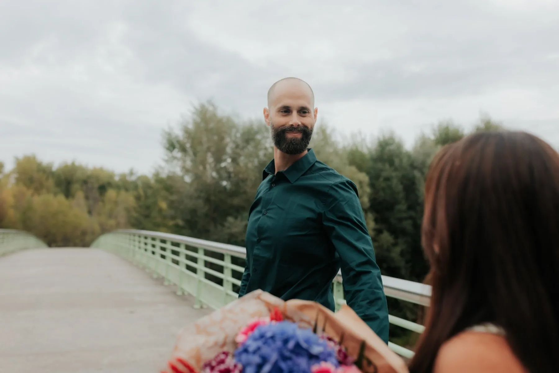 Couple au Stade des eaux vives à Pau lors d’une séance photo d’anniversaire romantique, avec bouquet de fleurs