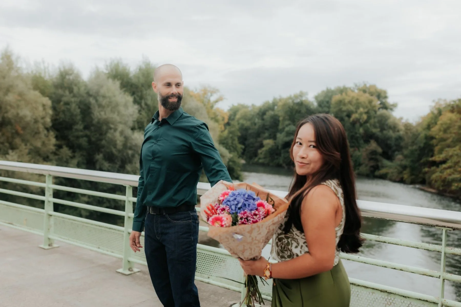 Couple main dans la main avec bouquet au Stade des Eaux-Vives à Pau, pour une séance photo d’anniversaire romantique