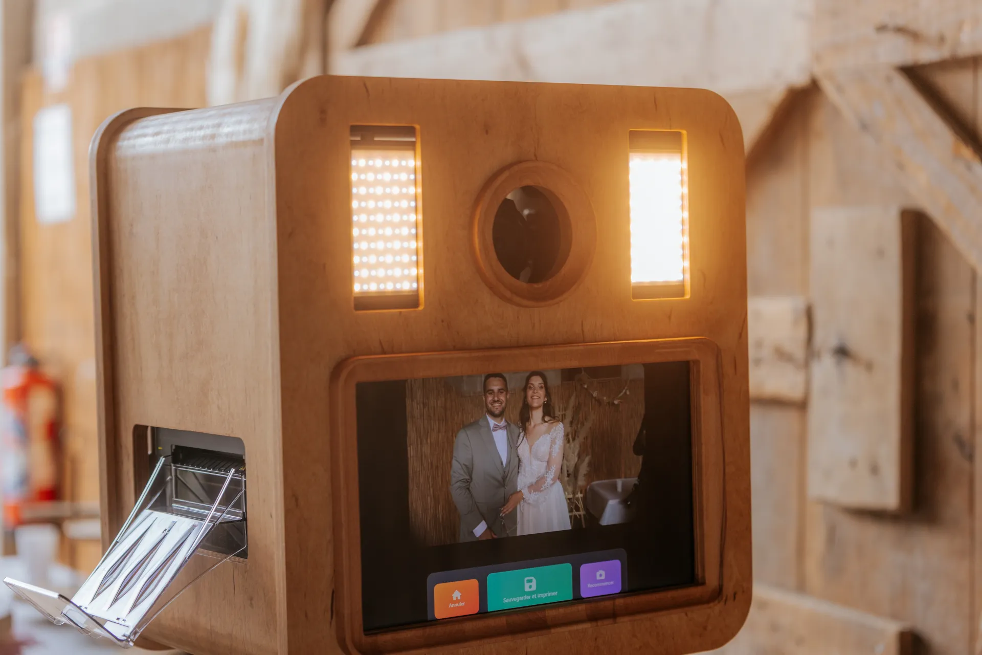 Photobooth mariage en bois à Pau avec écran tactile et éclairage LED dans une salle de réception chaleureuse