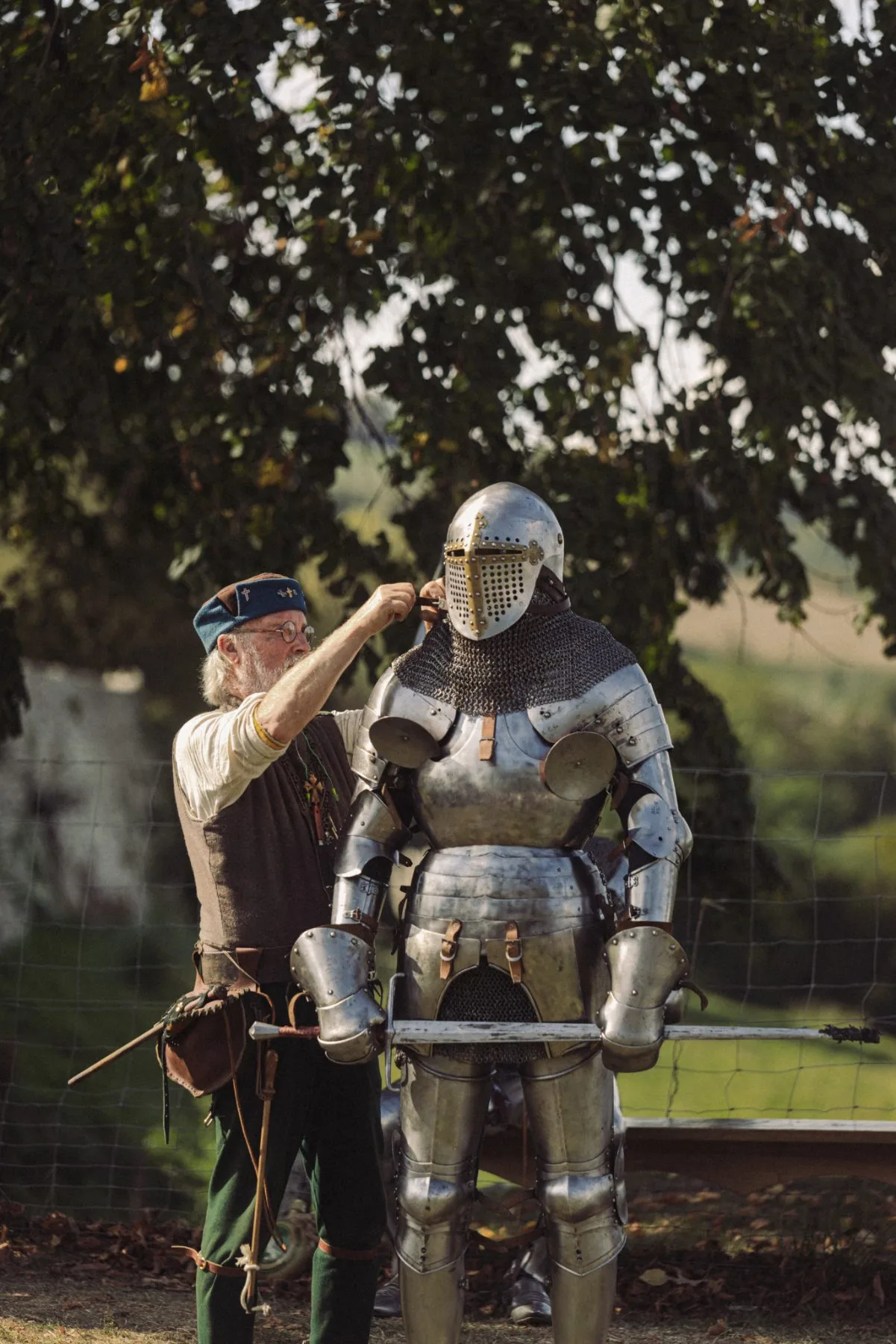 Artisan ajustant une armure médiévale au Château de Bidache lors d’un événement patrimonial immersif