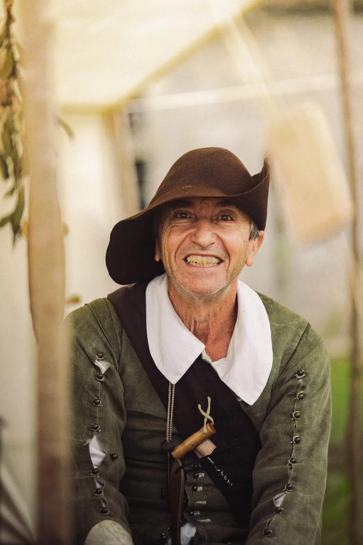 Participant en costume d’époque souriant au Château de Bidache lors d’un événement patrimonial immersif