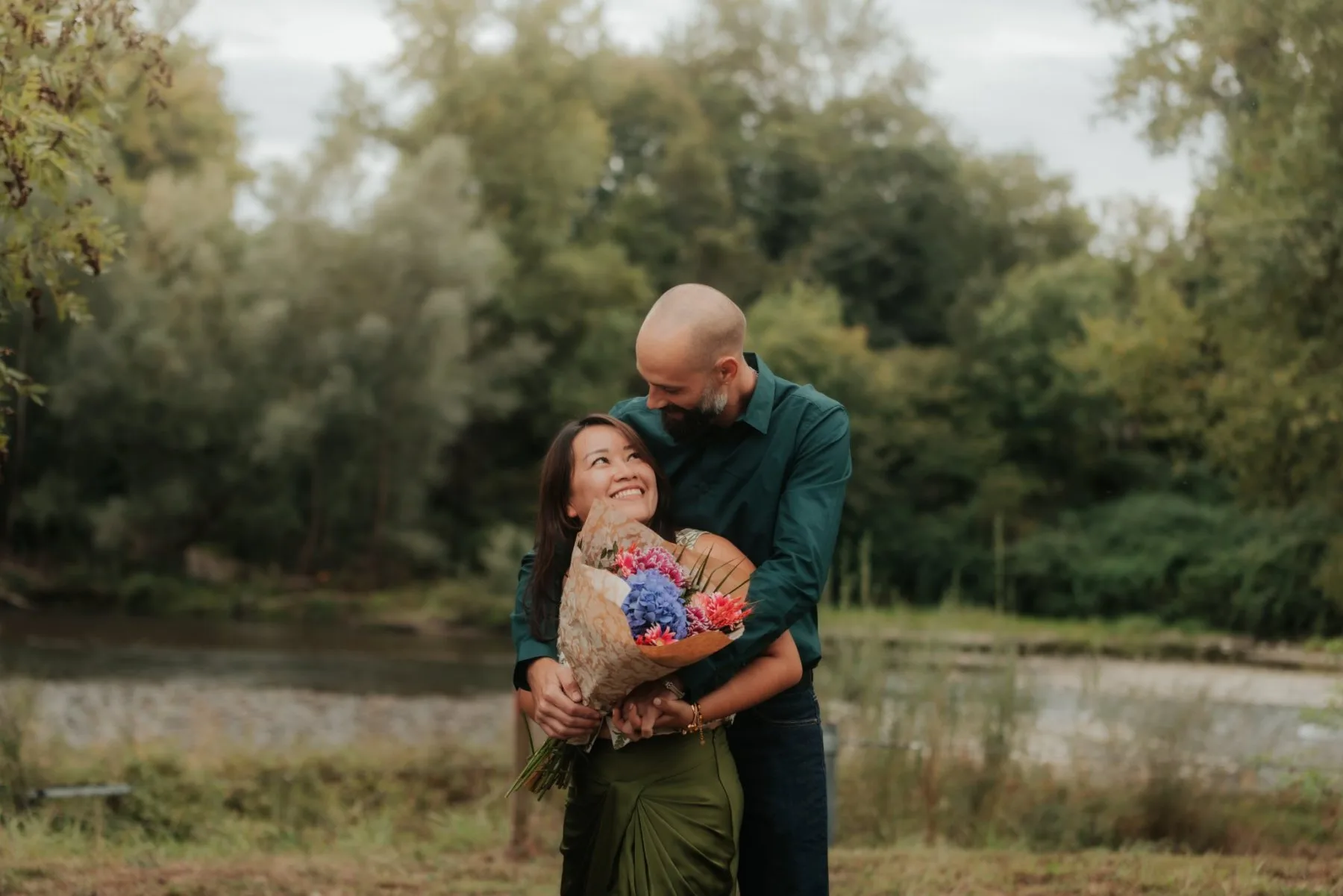 Couple enlacé avec bouquet au Stade des eaux vives à Pau, lors d’une séance photo d’anniversaire romantique