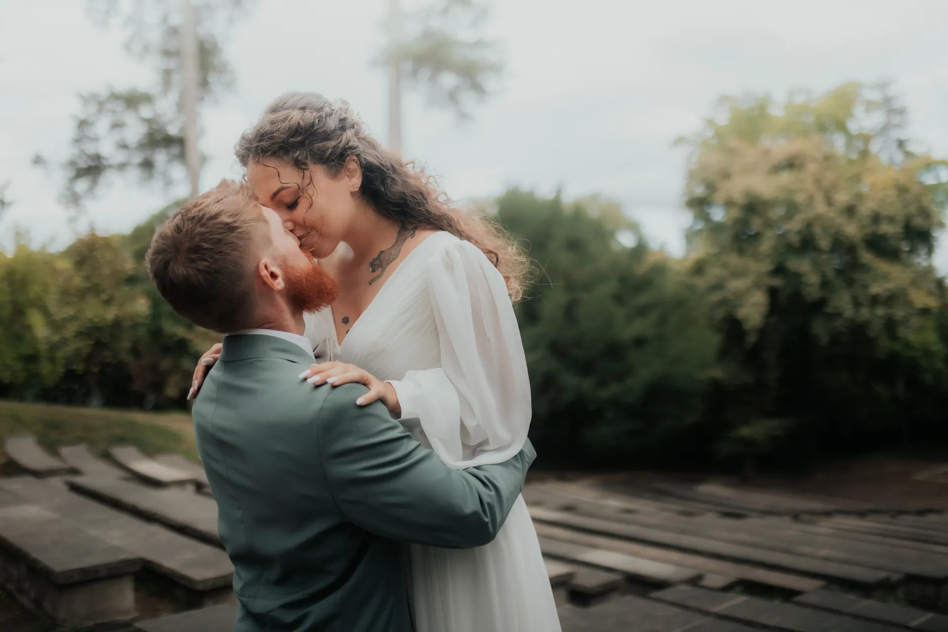Couple de mariés s’embrassant au Théâtre de Verdure à Pau, lors d’une séance photo mariage en lumière naturelle