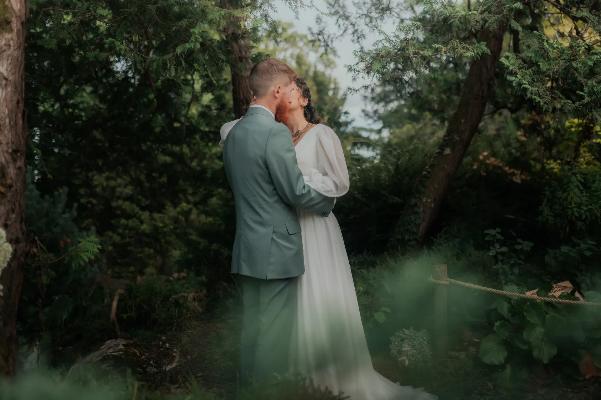 Couple de mariés s’embrassant au Théâtre de Verdure à Pau, séance photo de mariage romantique en pleine nature