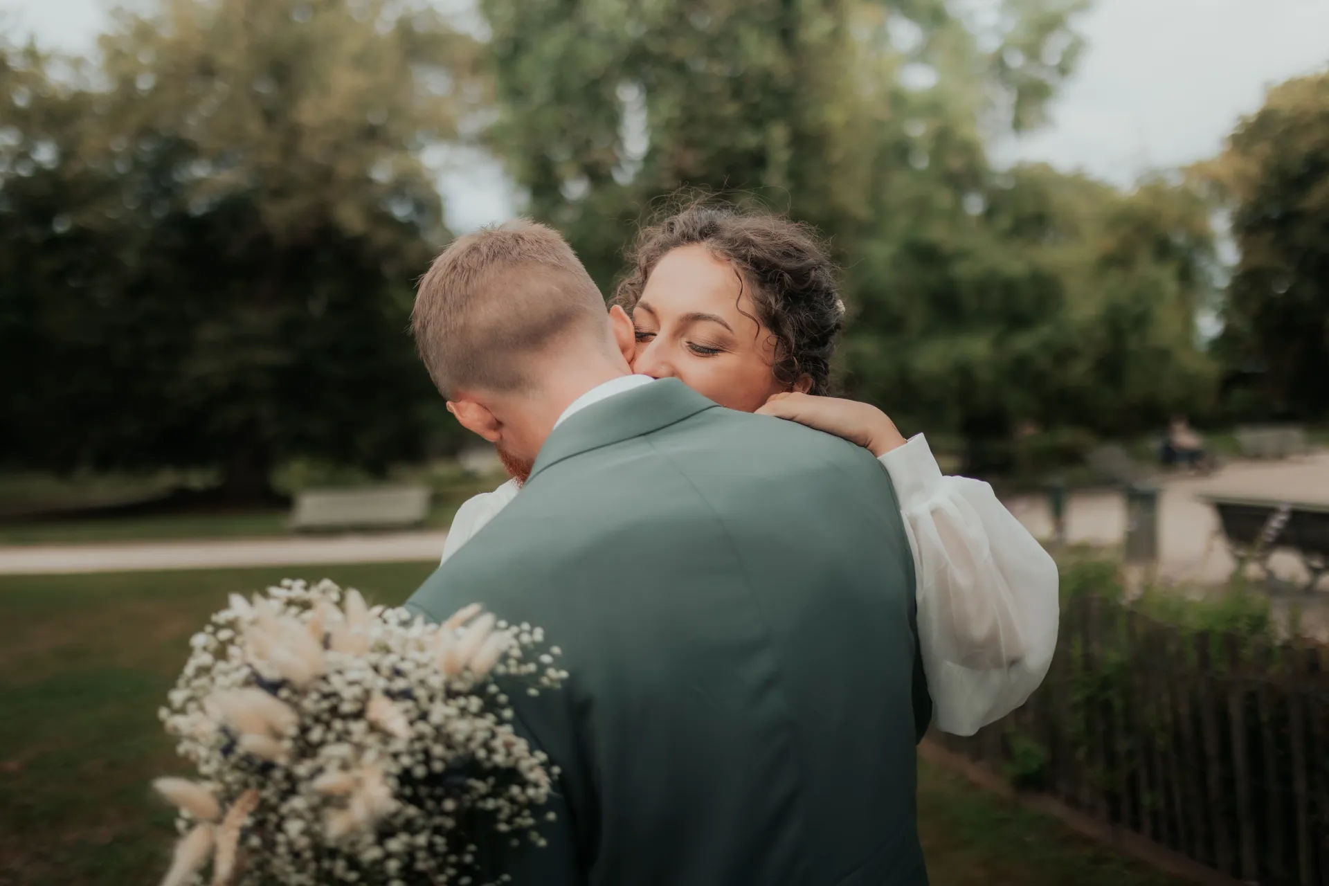 Couple de mariés enlacés au Théâtre de Verdure à Pau, séance photo mariage lifestyle en lumière douce