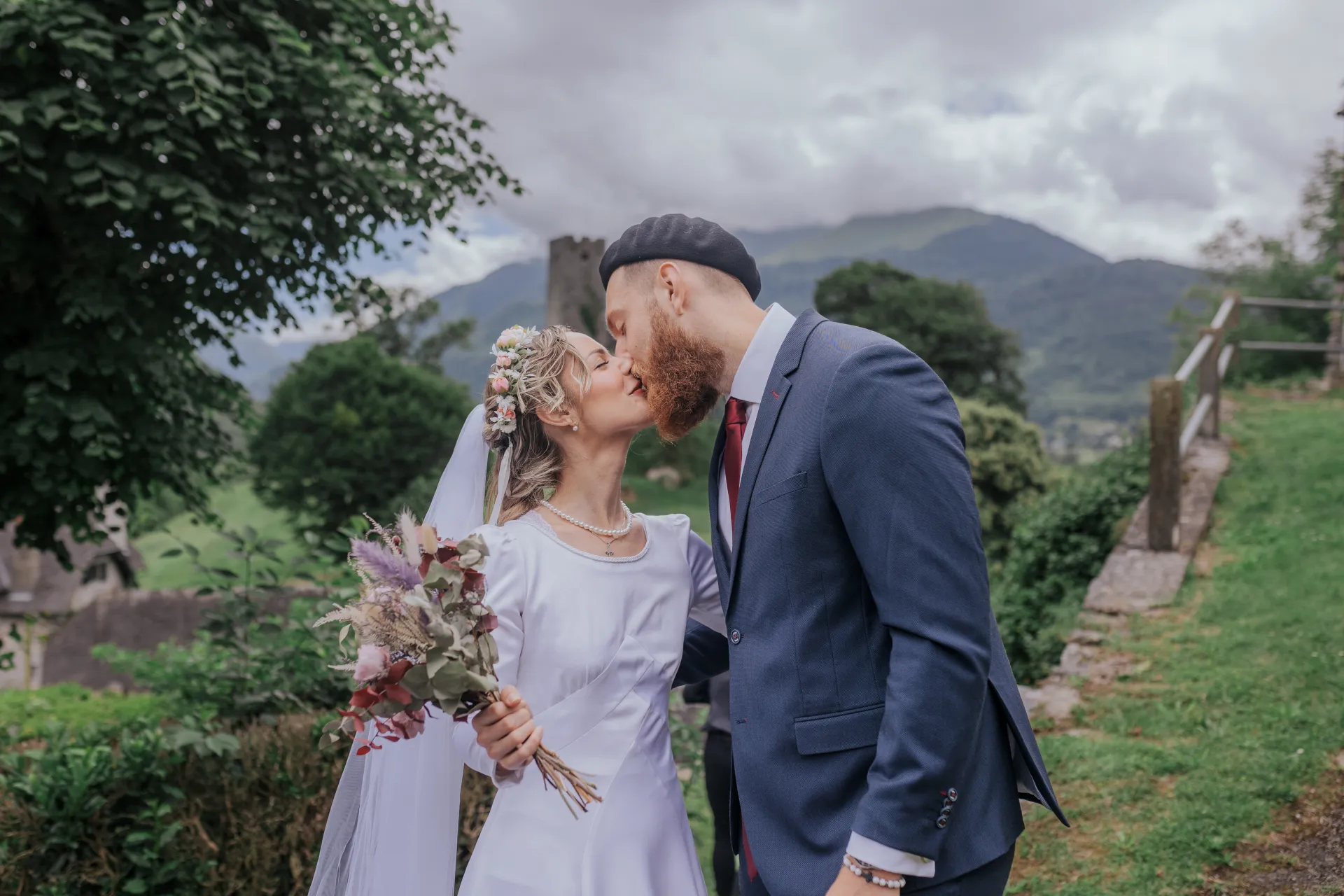 Mariés s’embrassant à Castet devant l’Église Saint-Polycarpe, séance couple de mariage au cœur des montagnes béarnaises