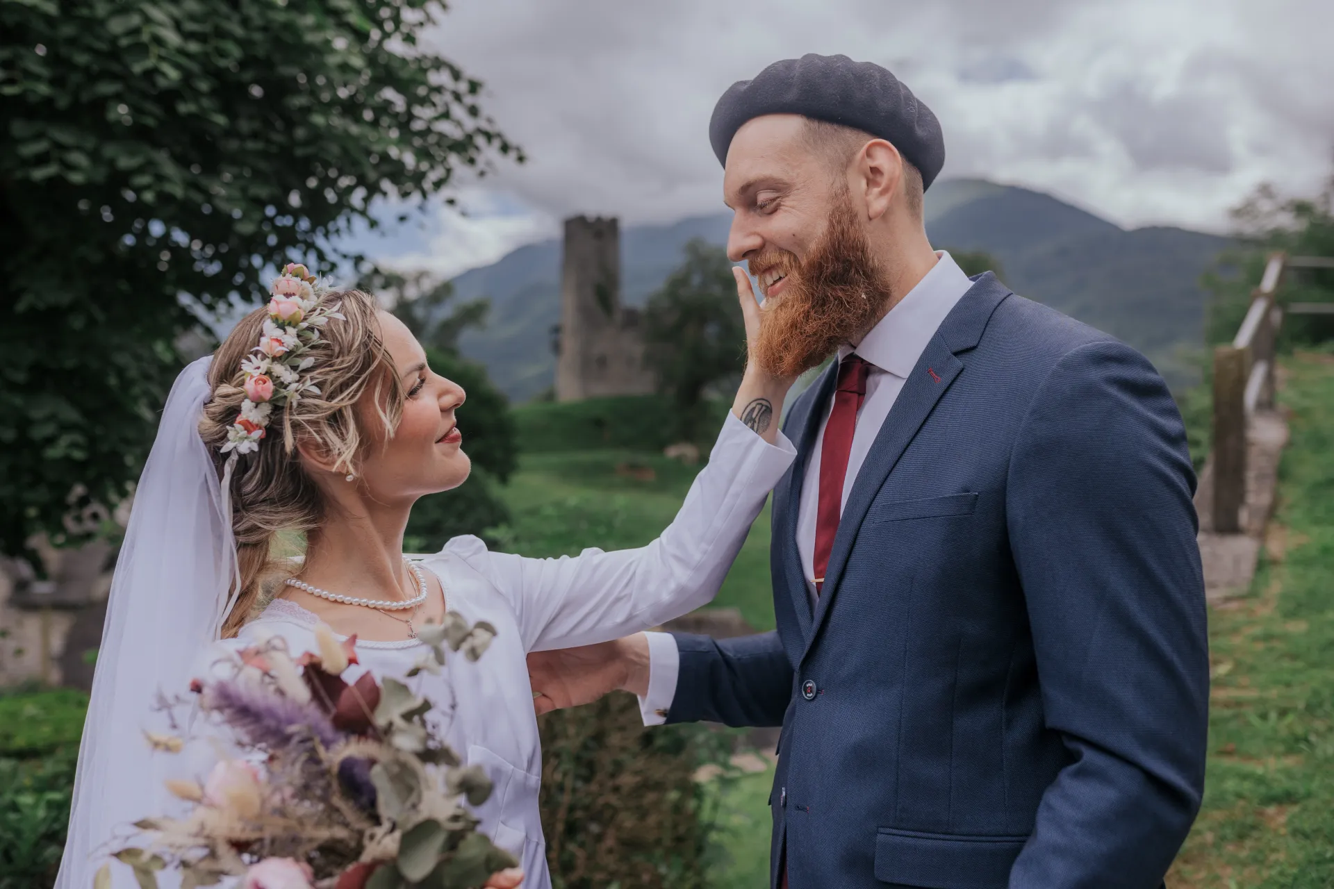 Mariés en séance couple à Castet devant l’Église Saint-Polycarpe, avec montagnes en arrière-plan