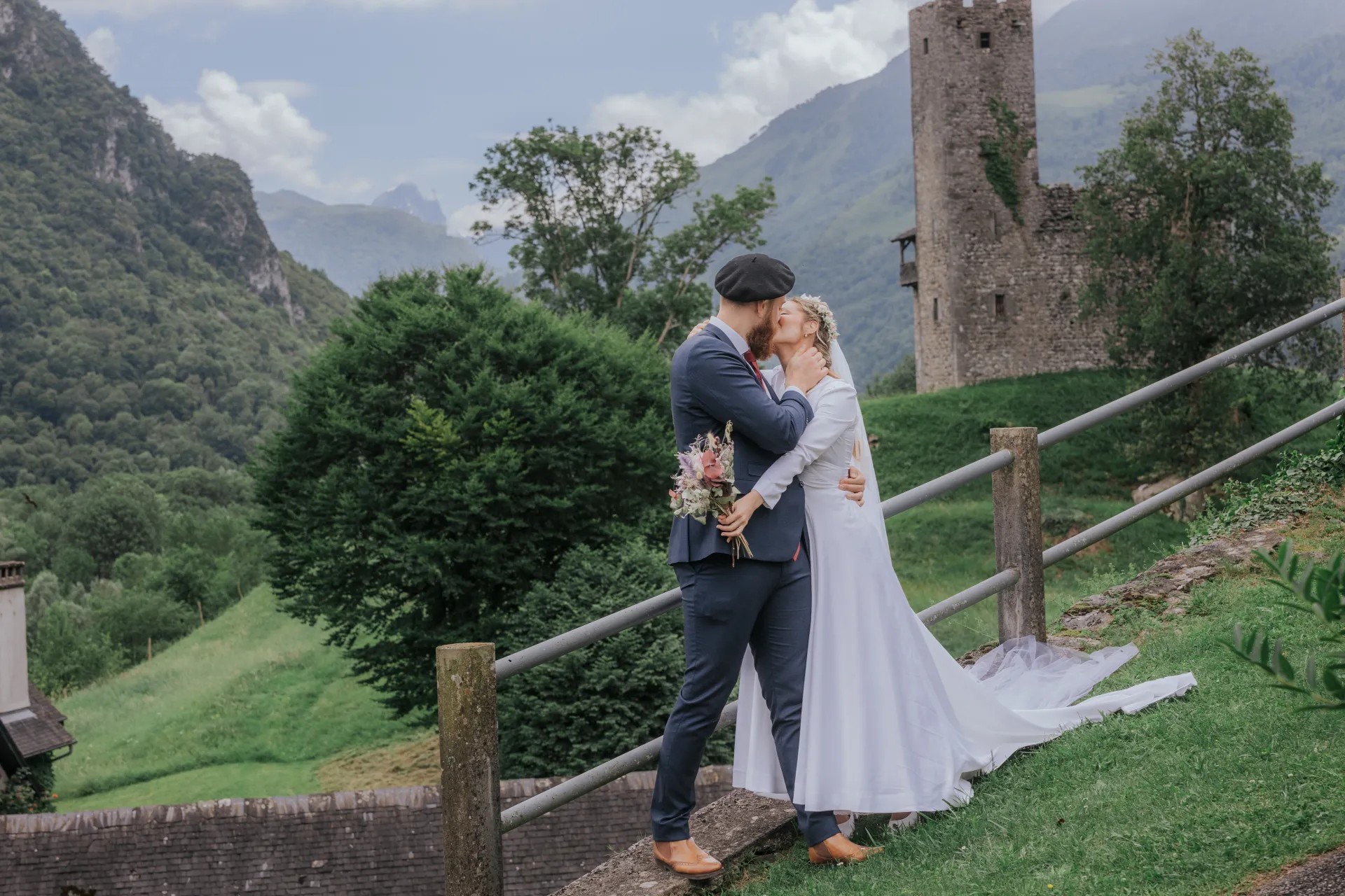 Mariés s’embrassant à Castet devant l’Église Saint-Polycarpe, séance couple au cœur des montagnes béarnaises