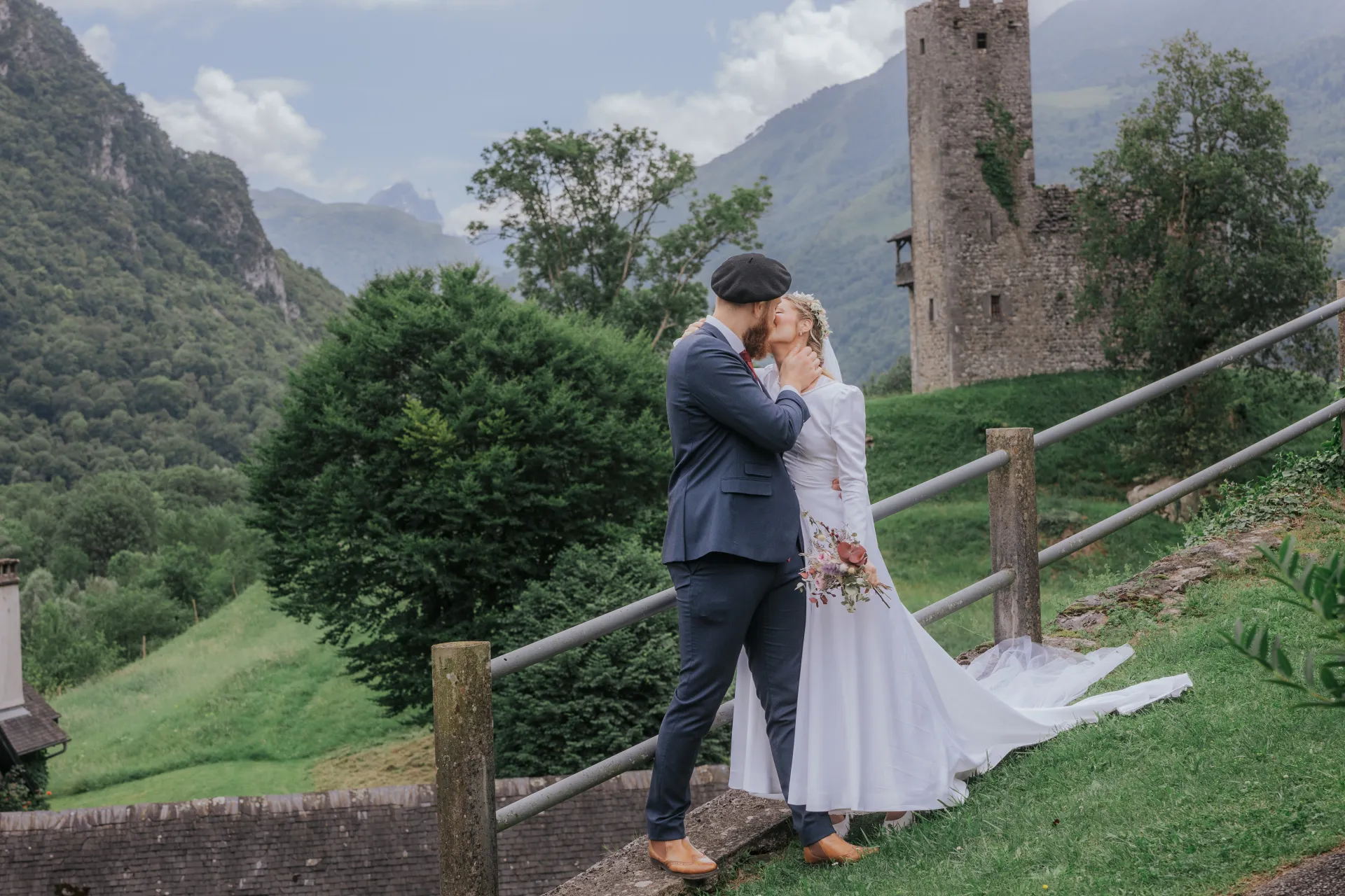 Mariés s’embrassant à Castet devant l’Église Saint-Polycarpe, avec vue sur les montagnes des Pyrénées