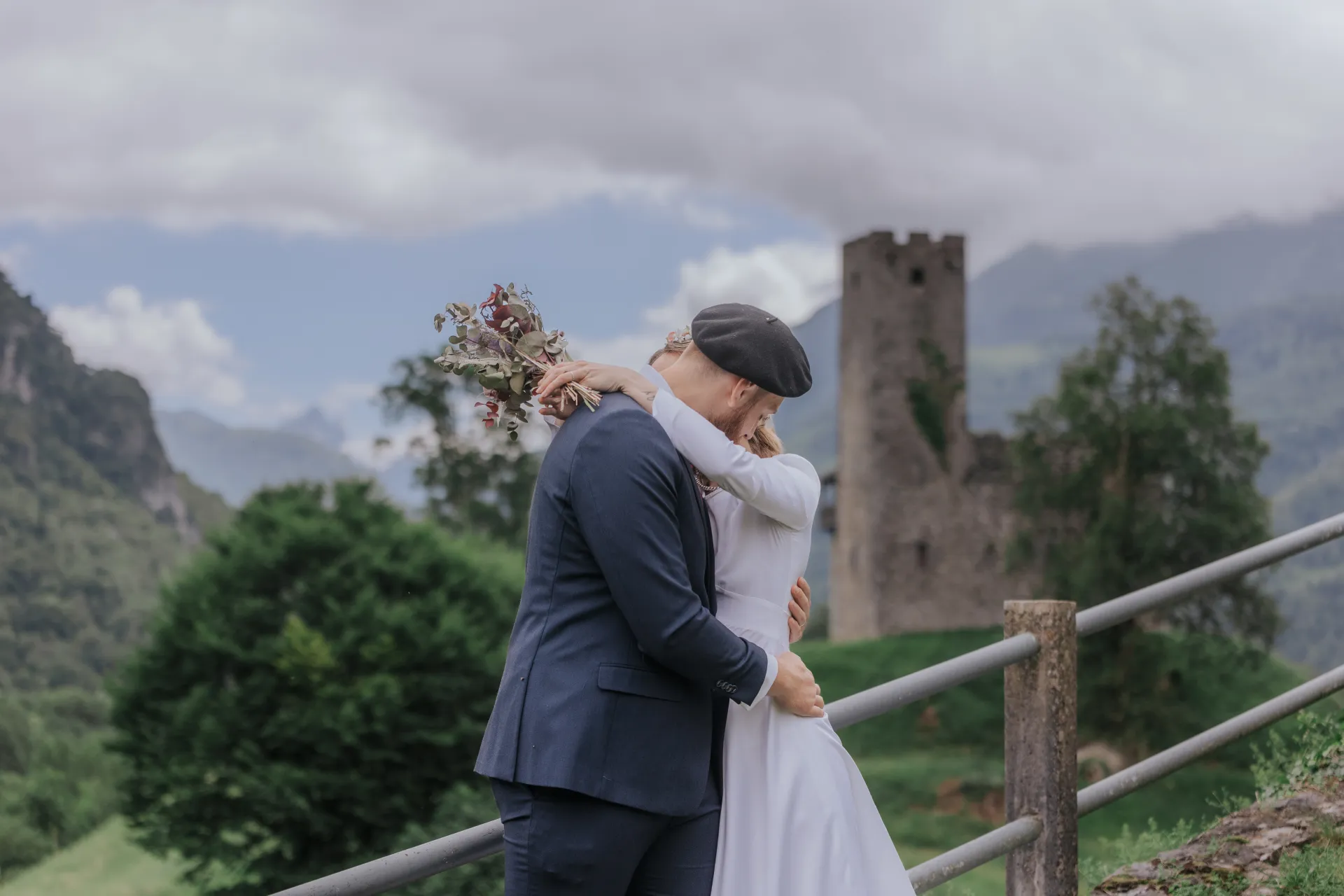 Mariés enlacés à Castet devant l’église Saint-Polycarpe, séance couple romantique en montagne