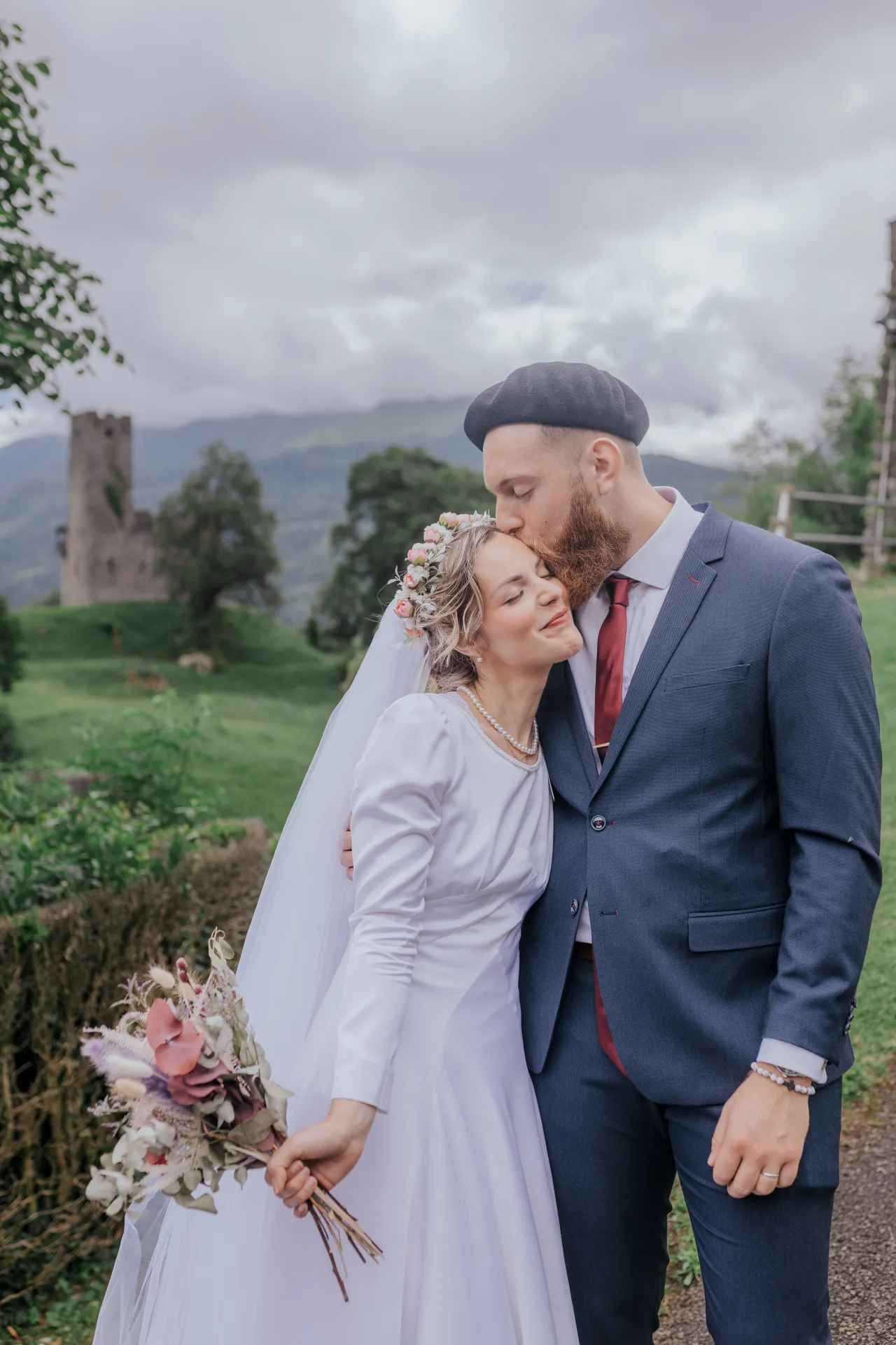 Mariés enlacés à Castet près de l’Église Saint-Polycarpe, séance couple romantique en montagne