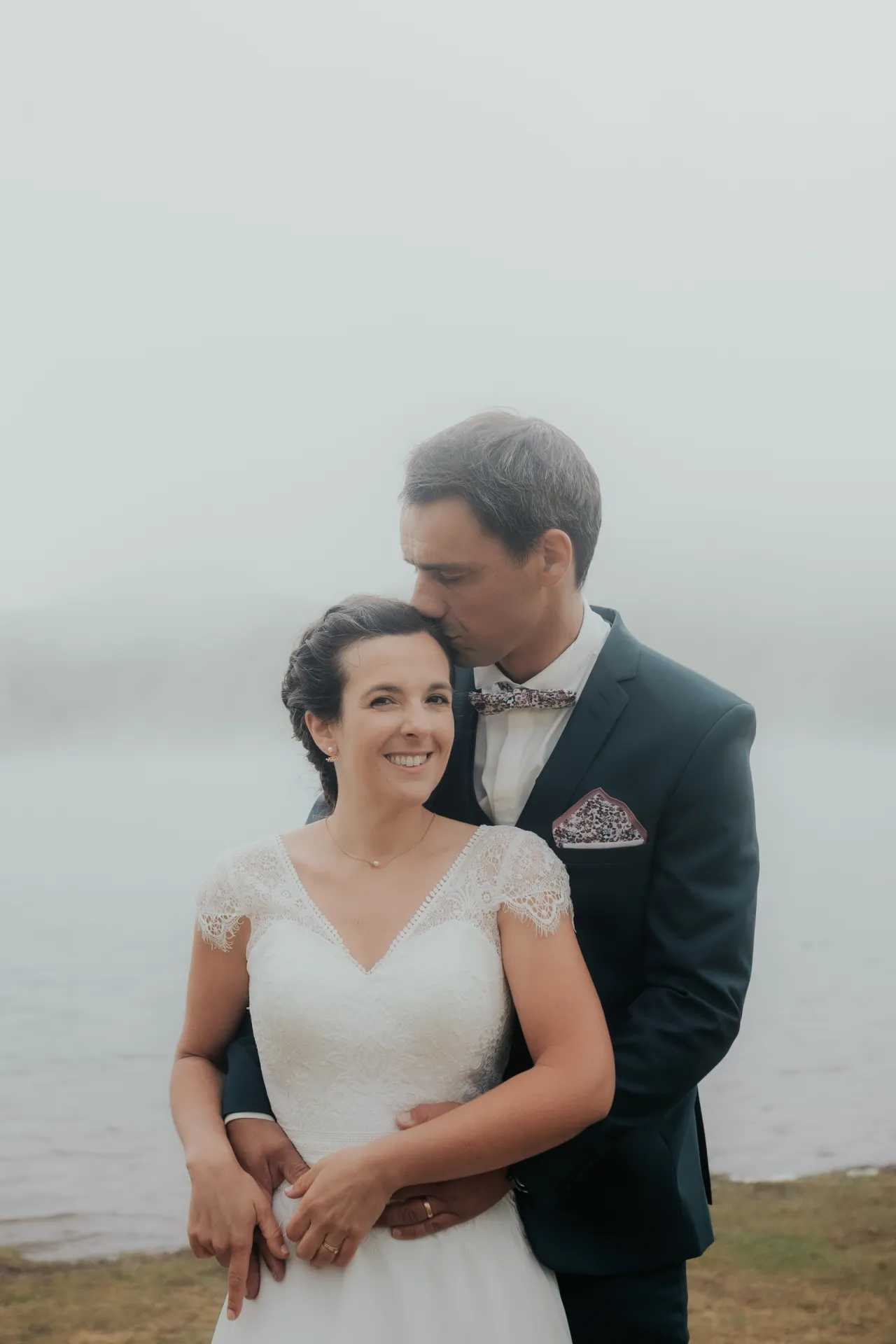 Couple de mariés enlacés au bord d’un lac lors d’une séance Day After aux Lacs d’Ayous, dans les Pyrénées-Atlantiques