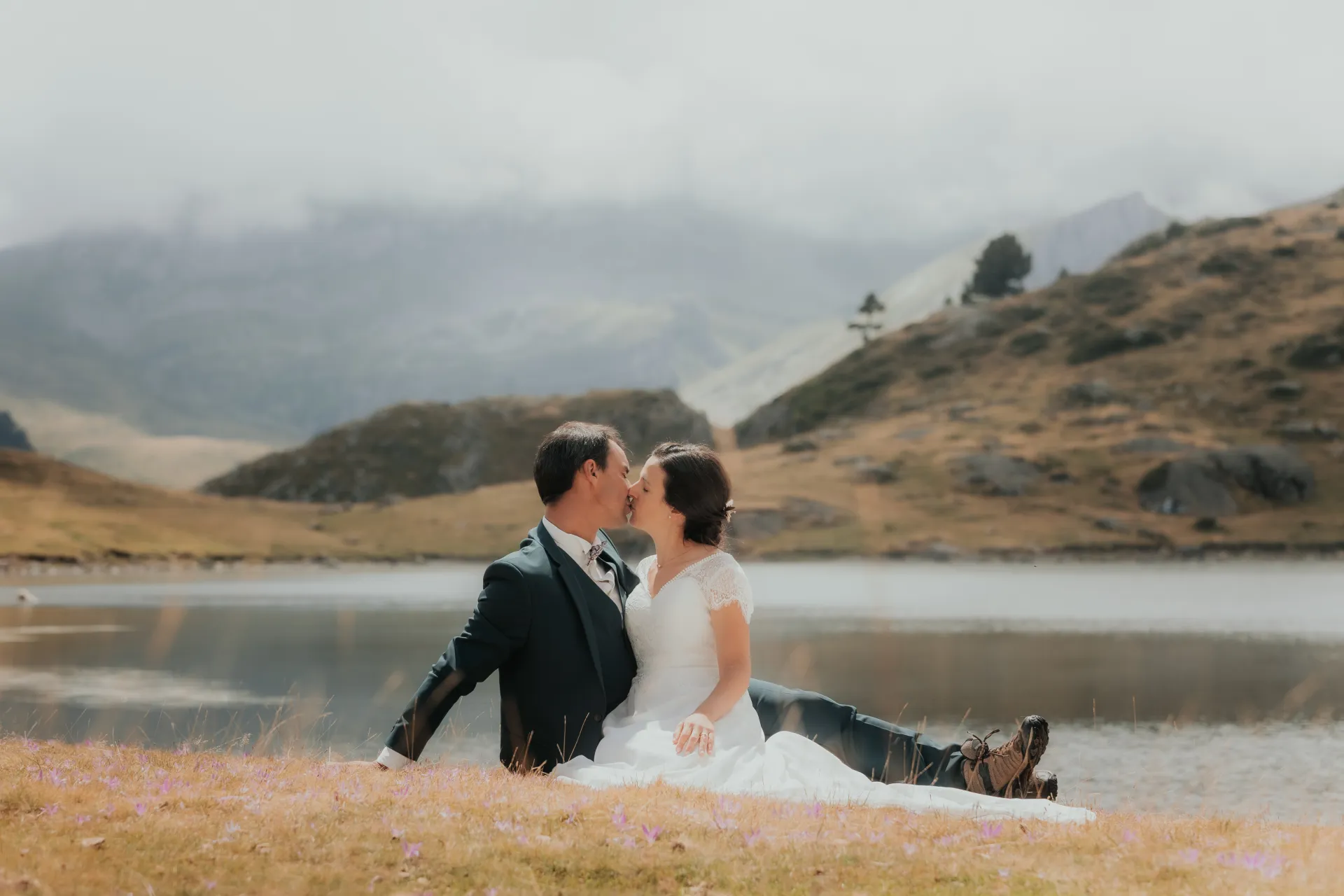 Couple de mariés s’embrassant au bord d’un lac aux Lacs d’Ayous, séance day after en montagne dans les Pyrénées-Atlantiques