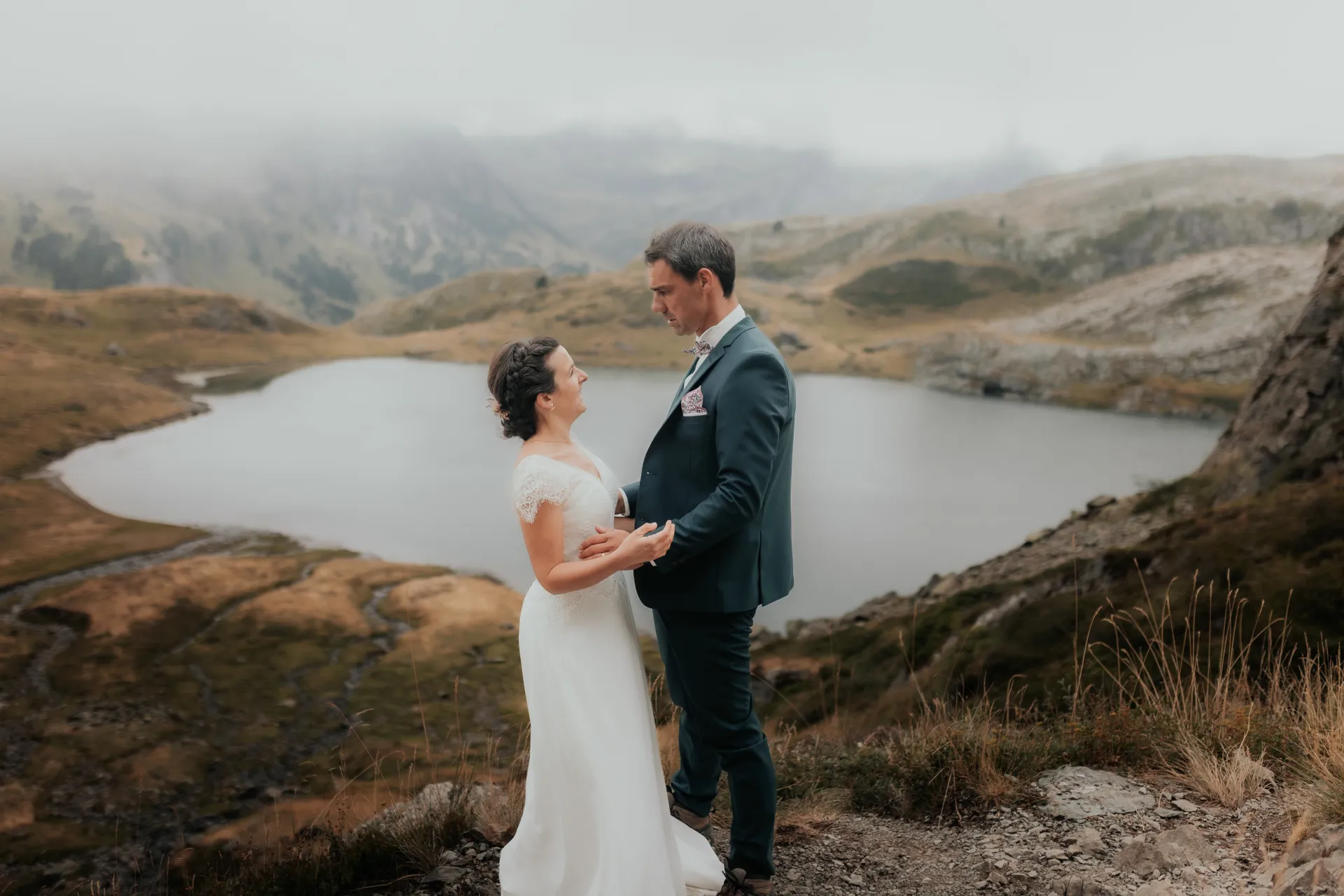 Couple de mariés en séance Day After aux Lacs d’Ayous, face au lac en montagne dans les Pyrénées-Atlantiques