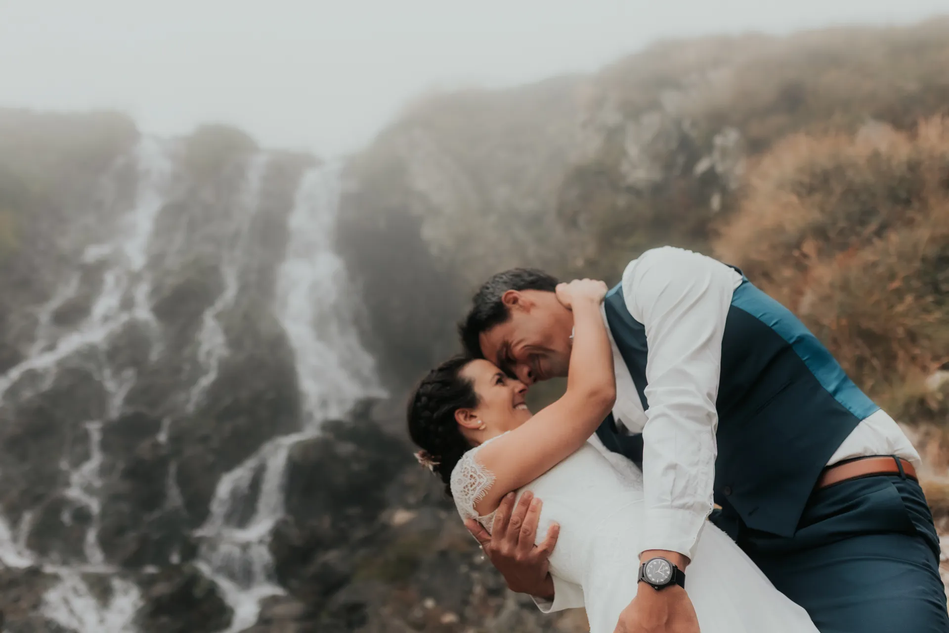 Couple de mariés enlacés devant une cascade aux Lacs d’Ayous, séance Day After en montagne dans les Pyrénées-Atlantiques