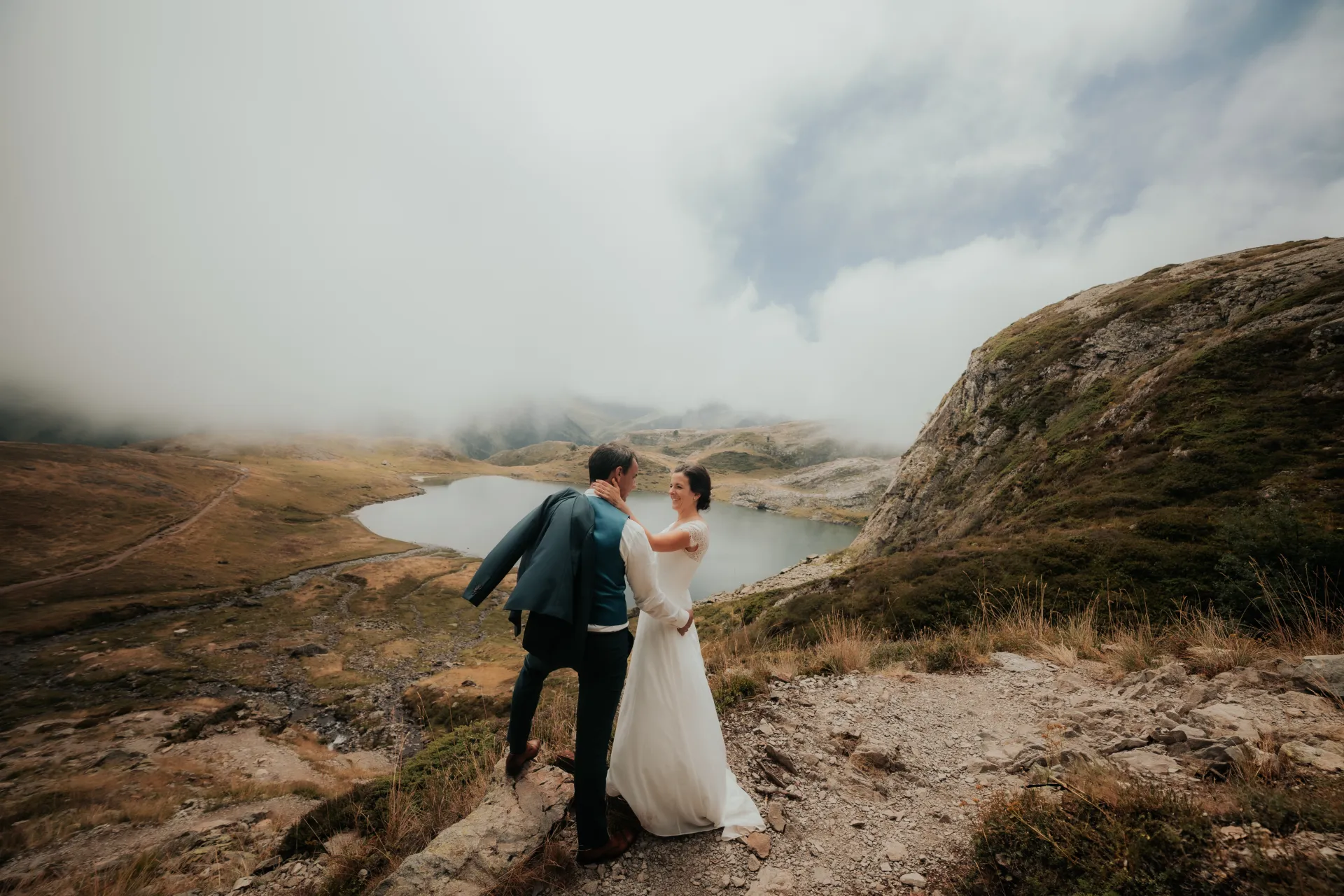 Couple de mariés en séance day after aux lacs d’Ayous, face au lac et aux montagnes des Pyrénées-Atlantiques