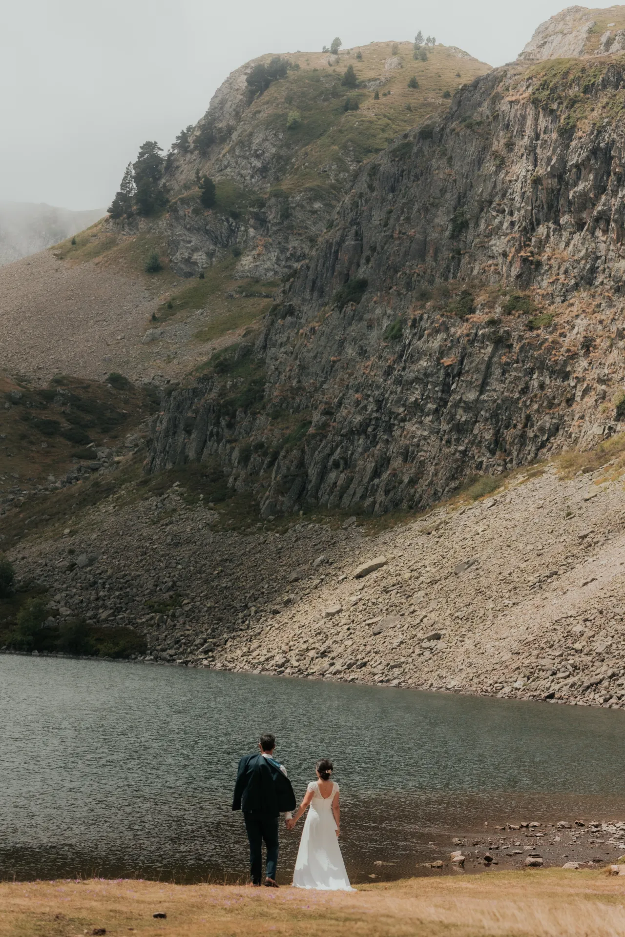 Couple de mariés au bord d’un lac de montagne aux Lacs d’Ayous, séance Day After dans les Pyrénées-Atlantiques