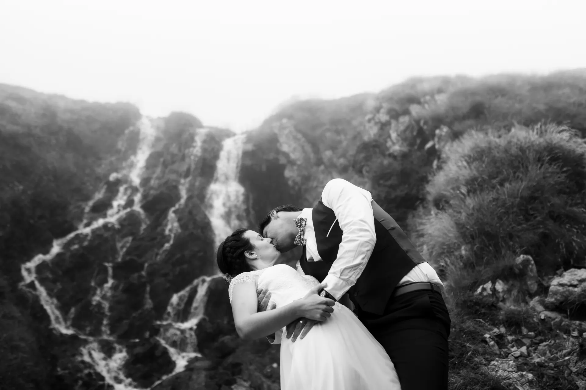 Couple de mariés s’embrassant devant une cascade aux lacs d’Ayous, séance Day After en montagne dans les Pyrénées-Atlantiques