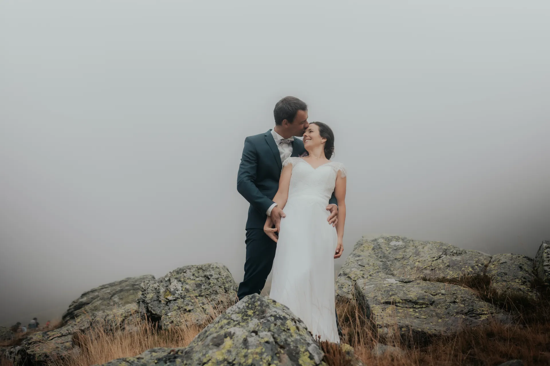 Couple de mariés enlacés dans la brume aux lacs d’Ayous, séance Day After en montagne dans les Pyrénées-Atlantiques