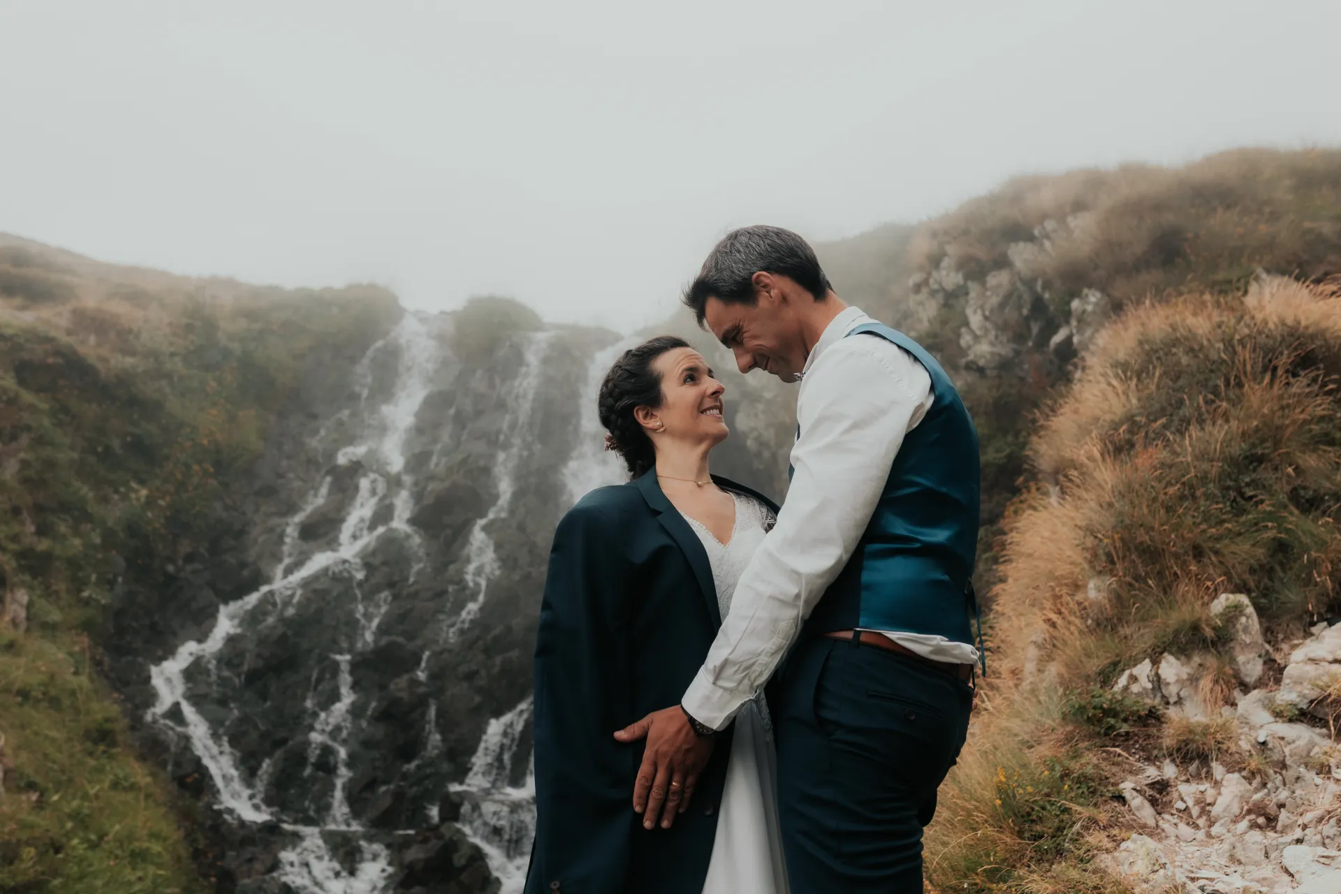 Couple de mariés en séance day after aux Lacs d’Ayous, devant une cascade en montagne dans les Pyrénées-Atlantiques