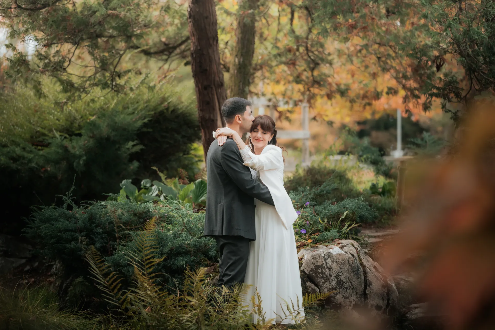 Couple de mariés enlacés dans un jardin à Pau, séance photo mariage romantique près du Boulevard des Pyrénées