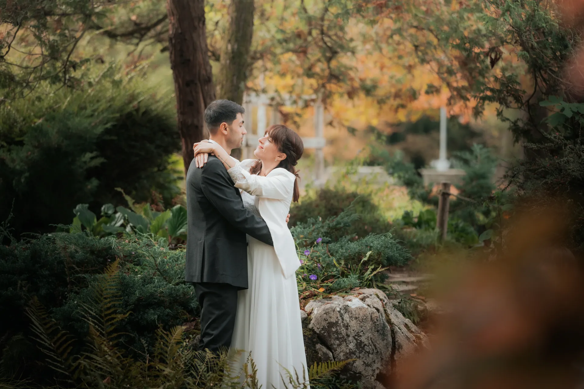 Couple de mariés enlacés dans un jardin à Pau, séance photo mariage romantique près du Boulevard des Pyrénées