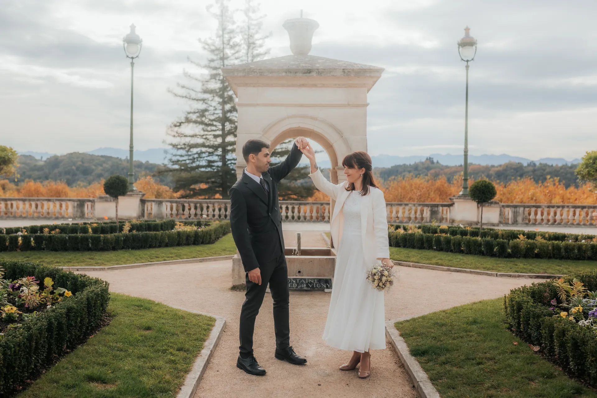 Couple de mariés dansant au Boulevard des Pyrénées à Pau, séance photo mariage romantique avec vue sur les jardins