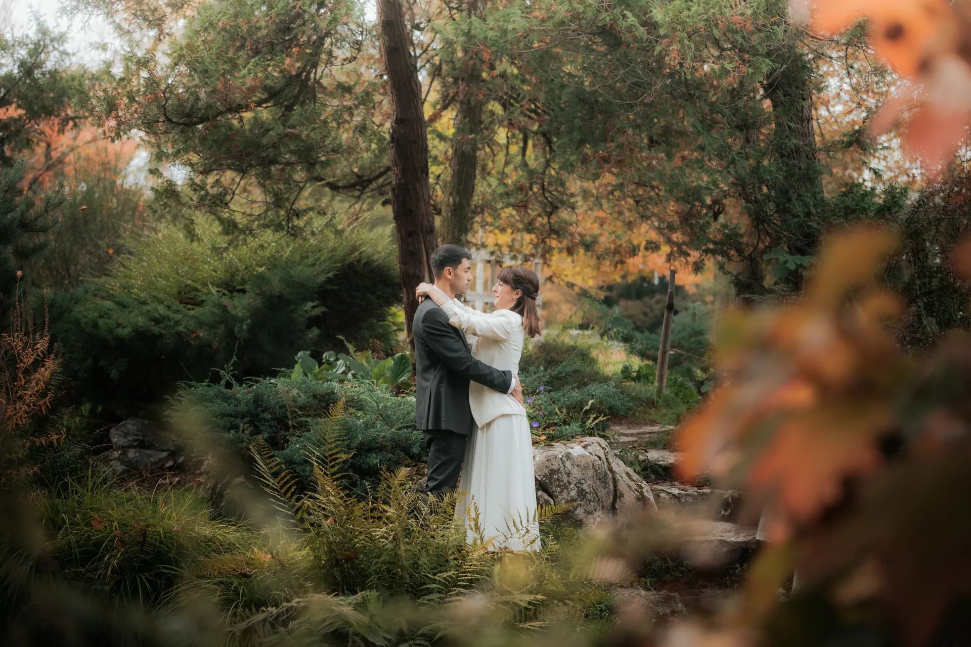Couple de mariés enlacés dans un jardin automnal à Pau, lors d’une séance photo mariage romantique