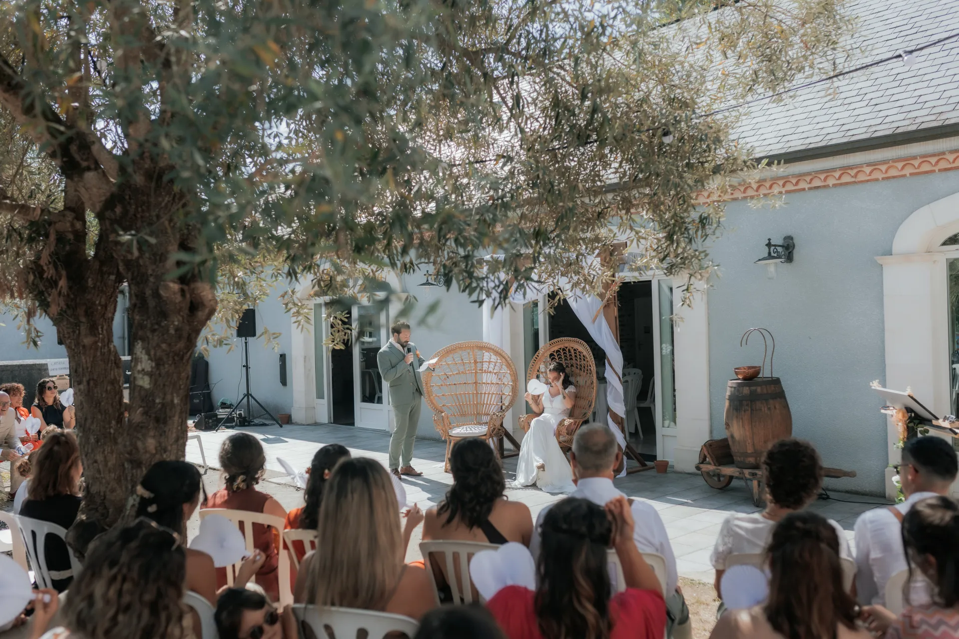 Cérémonie de mariage en extérieur à la Villa des 7 Moulins à Lescar, sous un olivier devant une salle lumineuse et élégante